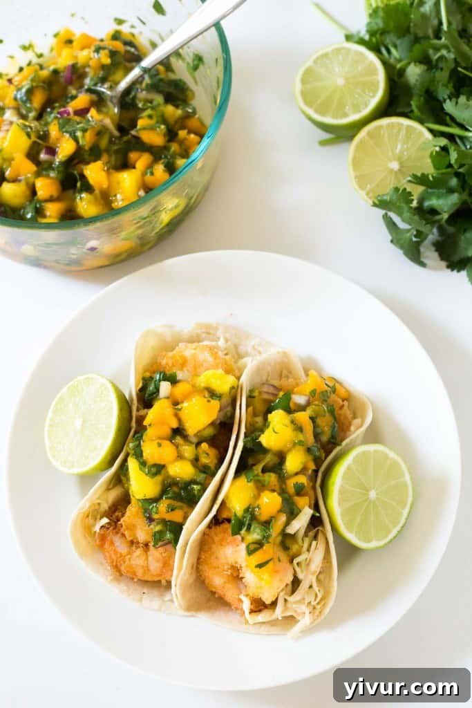 Tropical Coconut Shrimp Tacos with a chili lime coleslaw and mango papaya salsa - seriously the BEST taco I have ever had! Crispy, flavorful perfection.