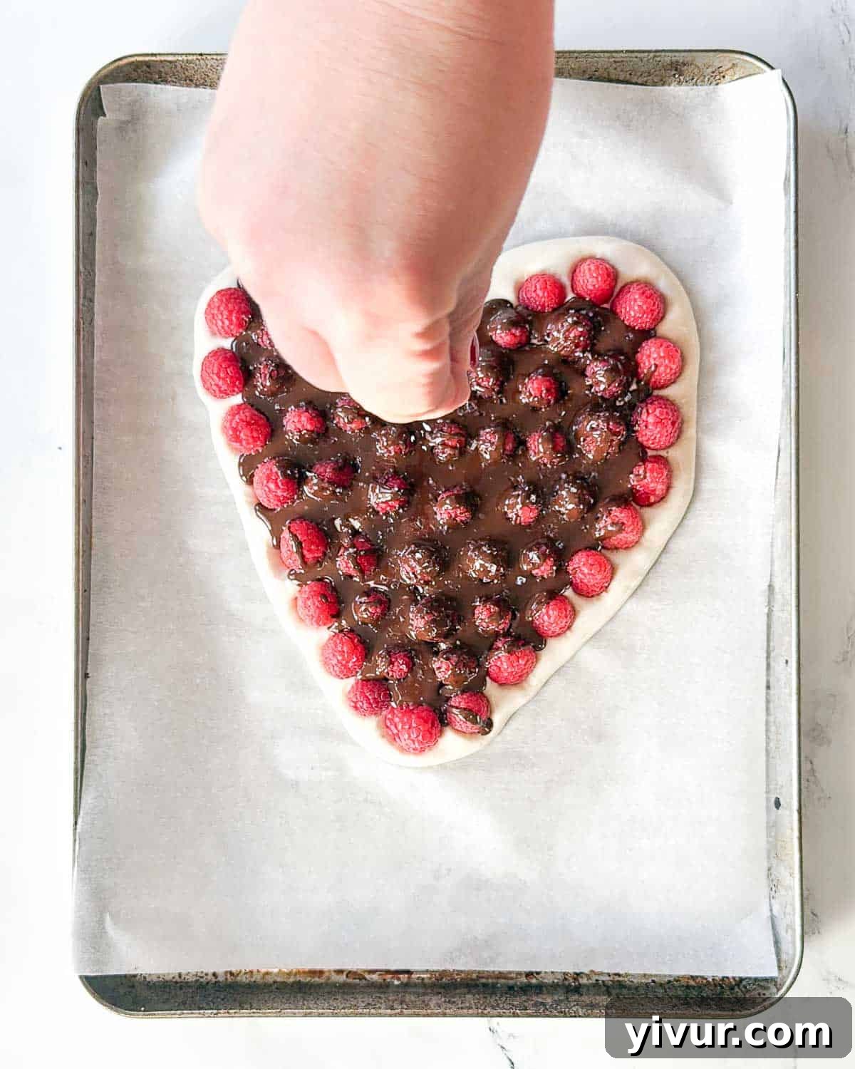 A generous sprinkling of flaky sea salt is scattered over the still-wet melted chocolate drizzle on the yogurt bark, enhancing both flavor and texture.