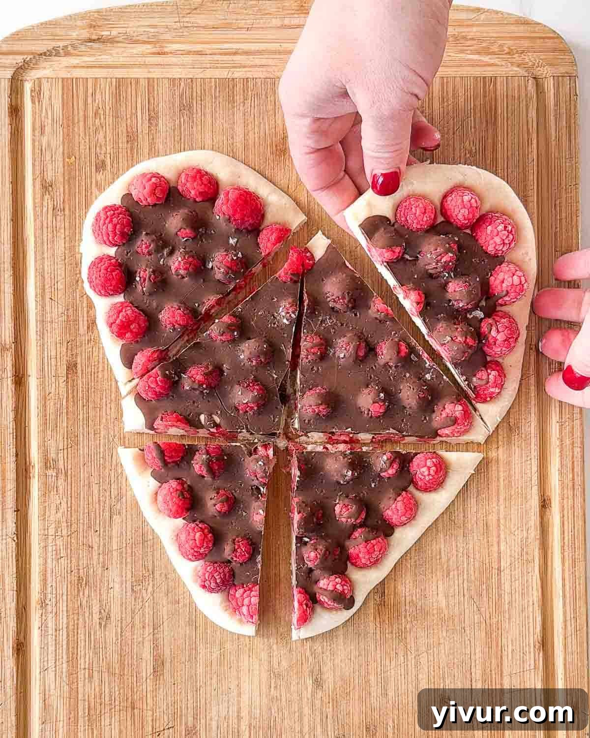 The fully assembled chocolate raspberry yogurt bark heart, neatly sliced into individual portions, resting on a white surface, ready to be enjoyed.