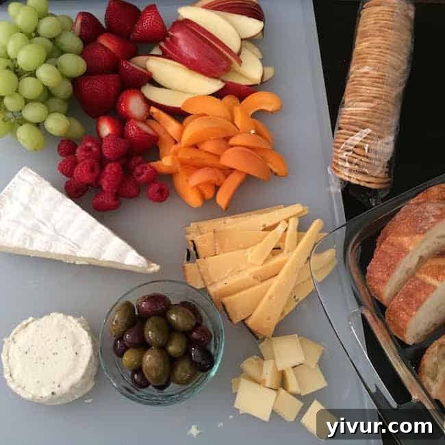 Delicious cheese and fruit board featuring an assortment of cheeses, fresh berries, grapes, and crackers, perfect for a Game of Thrones viewing party