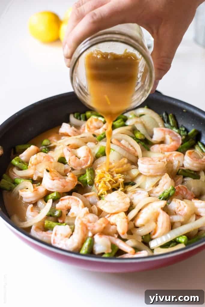 Bright and colorful Lemon Shrimp & Asparagus Stir Fry in a skillet, ready to serve