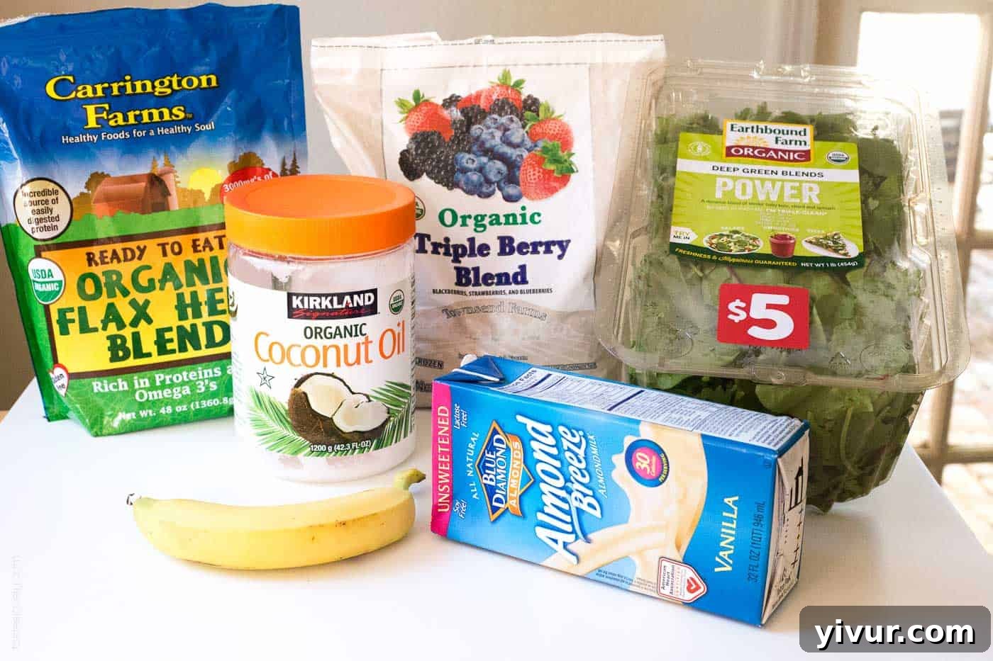 An array of fresh and frozen organic ingredients laid out, ready for making a healthy pregnancy superfoods smoothie.