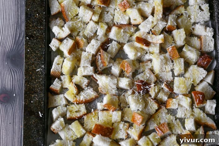 Crispy Garlic Parmesan Croutons 13 Before baking: Plain hunks of bread cubes on a parchment-lined baking sheet, awaiting transformation.