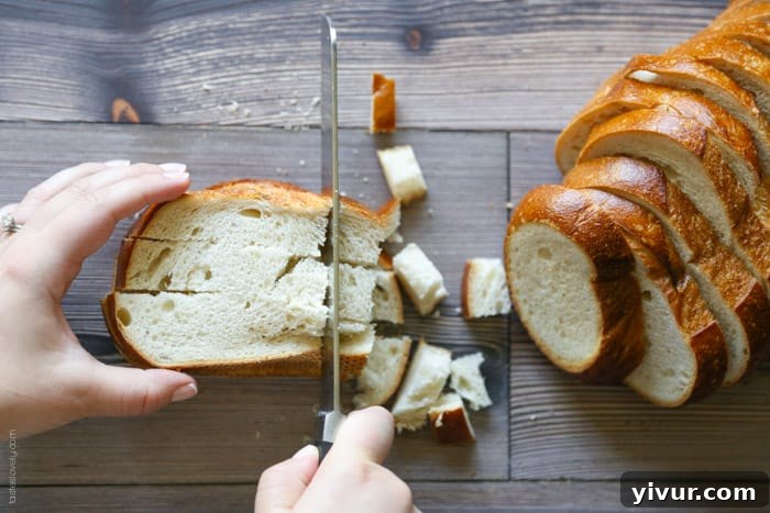 Crispy Garlic Parmesan Croutons 6 Bread strips being cut crosswise into small, even cubes, forming the basis for homemade croutons.