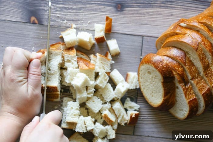 Crispy Garlic Parmesan Croutons 7 Close-up of freshly cut sourdough bread cubes, approximately three-quarters of an inch, on a cutting board.