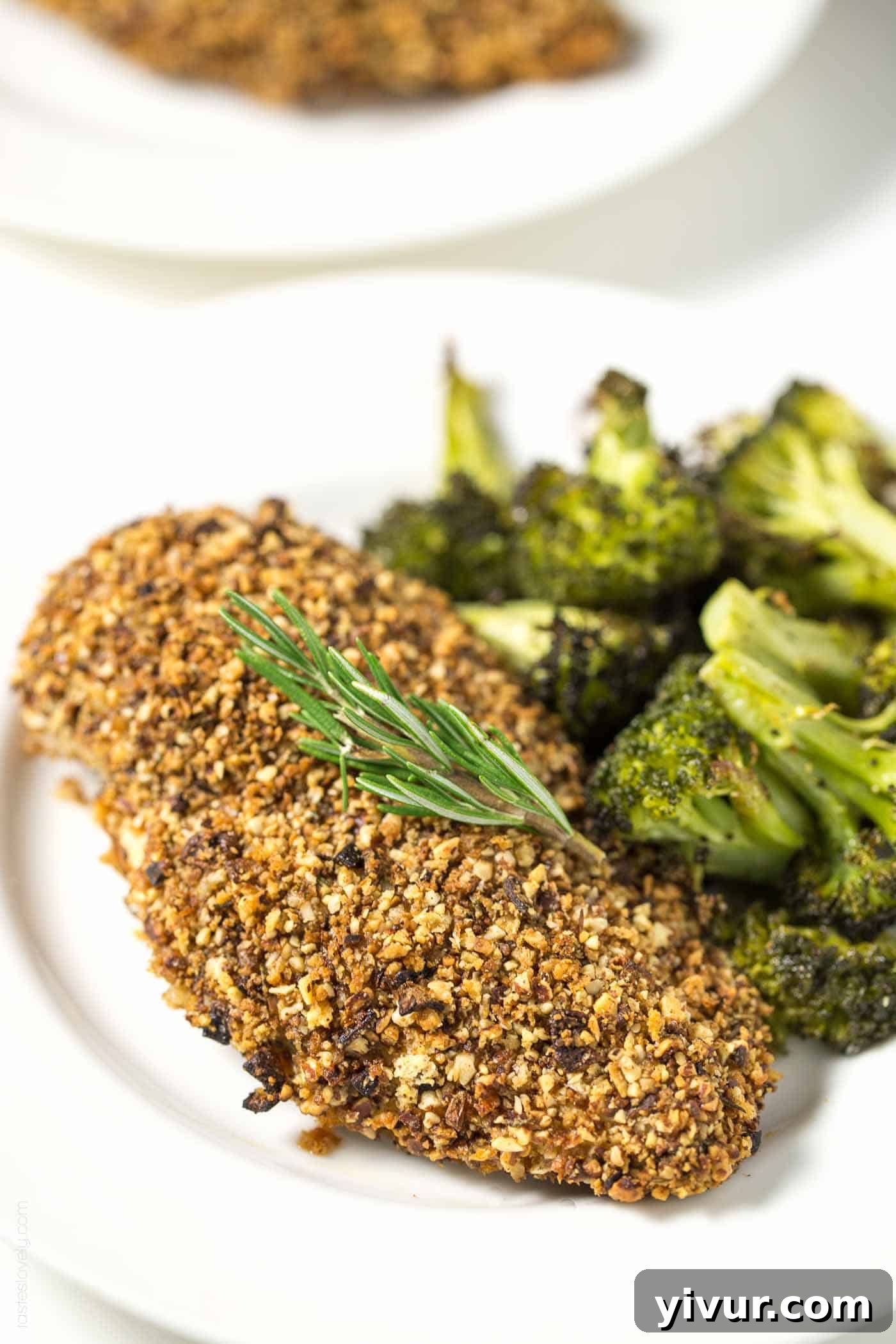 almond crusted chicken on a white plate with roasted broccoli 