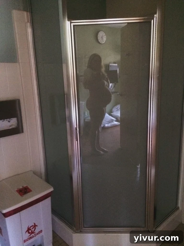 A pregnant woman at 34 weeks, capturing a last belly photo before C-section