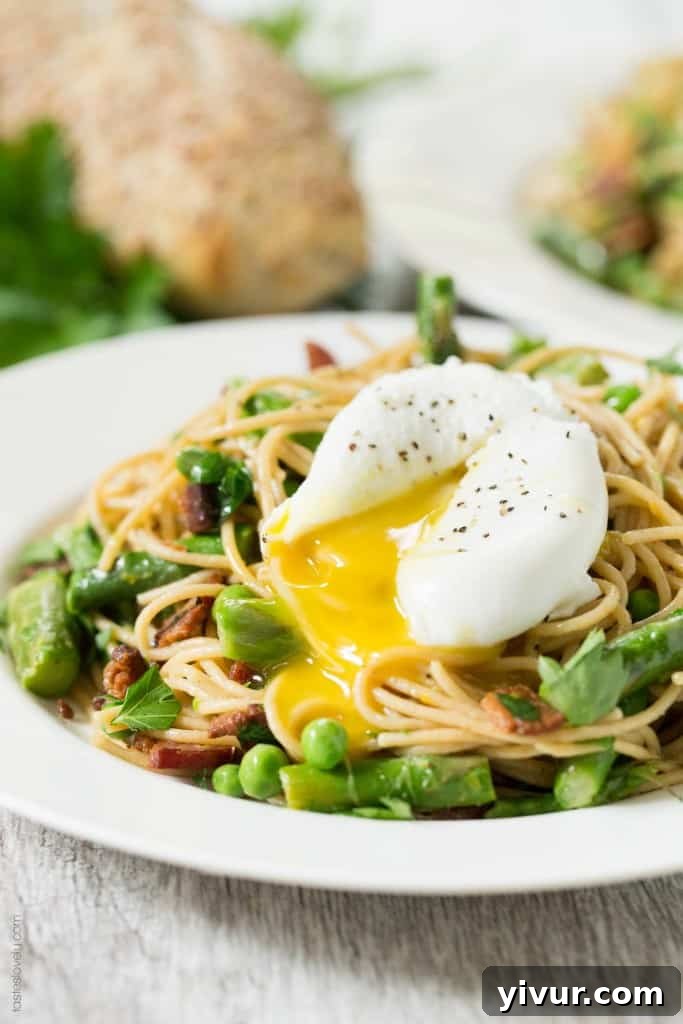 Delicious Spring Pasta with Crispy Bacon and a Perfectly Poached Egg, garnished with fresh parsley and lemon zest, ready for a light and healthy meal.