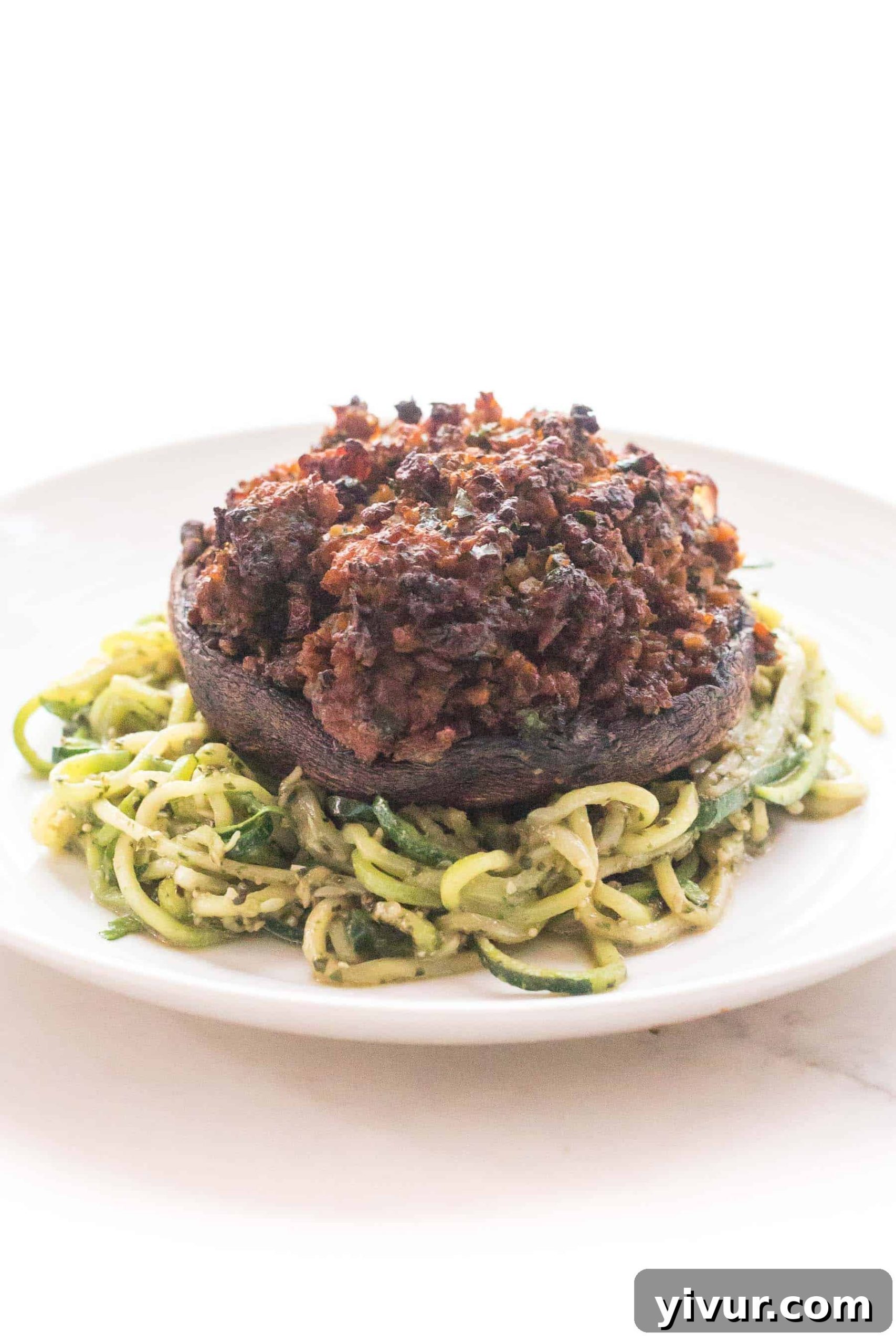 savory sausage stuffed portobello mushrooms over zucchini noodles, close up