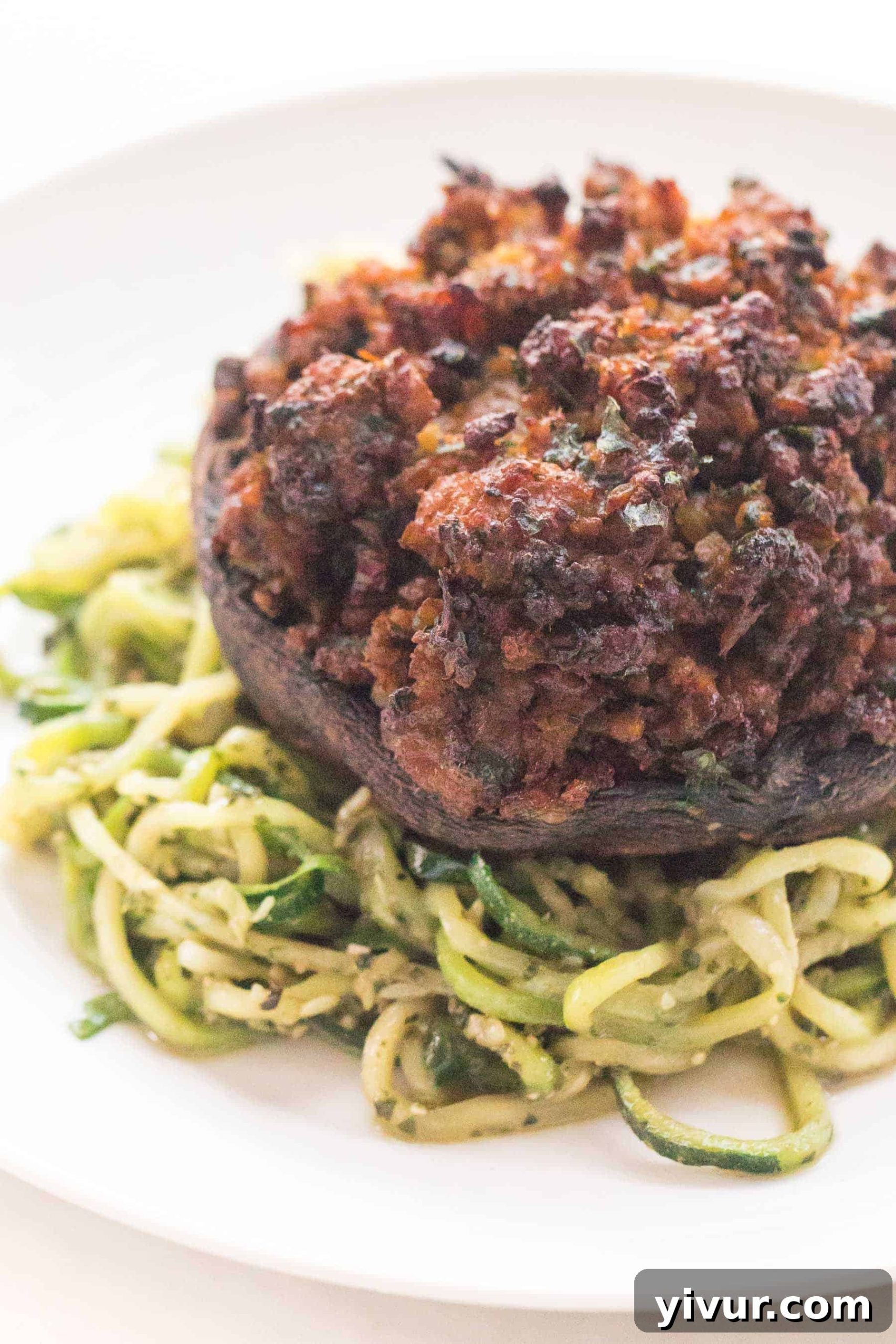 a closeup of keto stuffed mushrooms over zucchini noodles