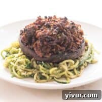 a closeup of keto stuffed mushrooms over zucchini noodles