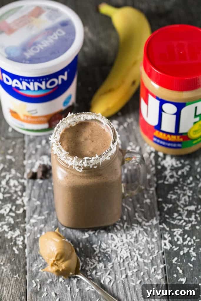 A perfectly blended Peanut Butter Cocoa Coconut Smoothie in a clear glass, ready to be enjoyed, showcasing its creamy texture.