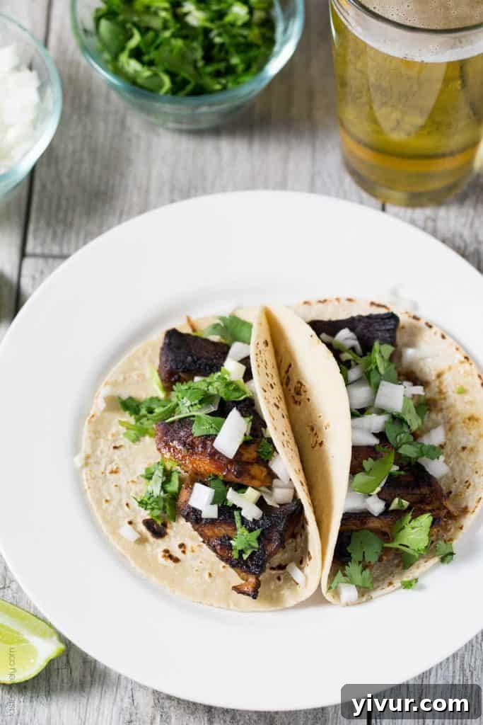 Close-up of succulent slow-cooked carnitas pork, ready for the broiler