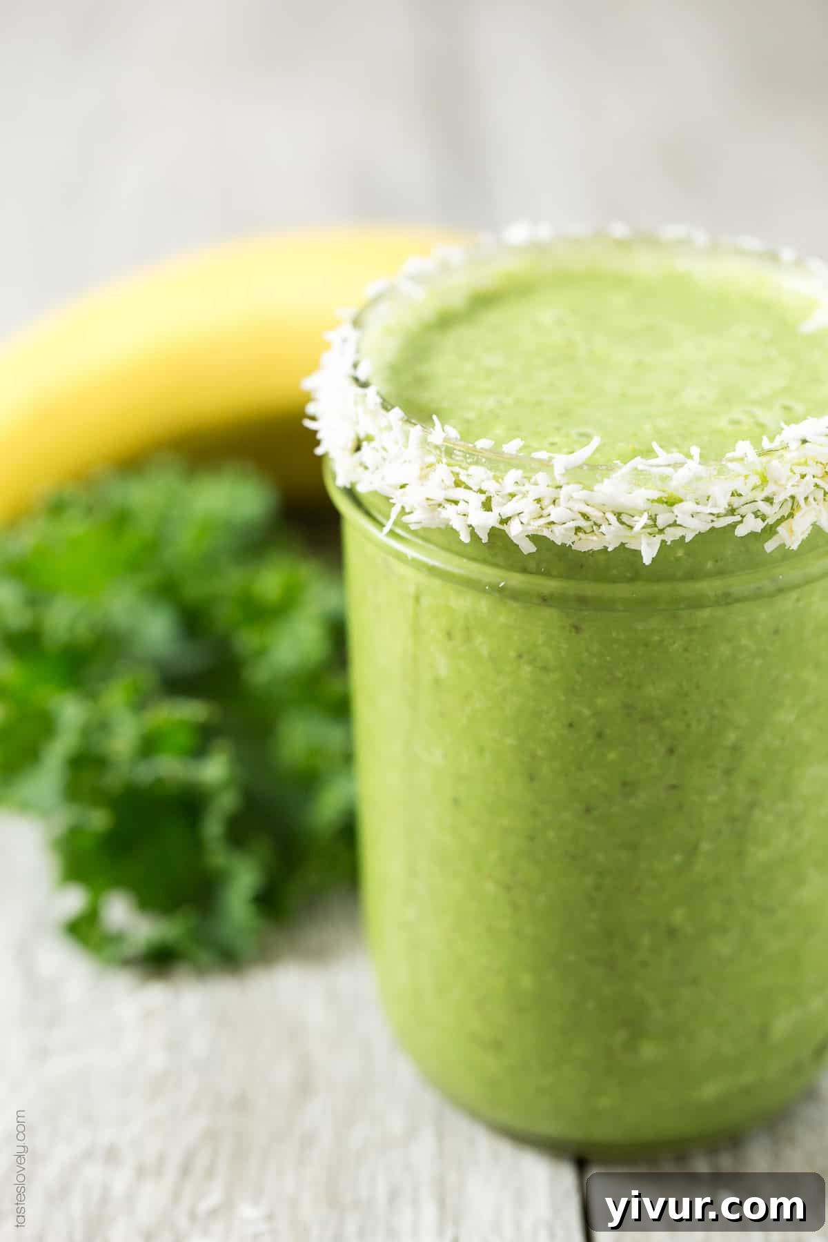 Kale Coconut Green Smoothie on a counter, with ingredients subtly in the background
