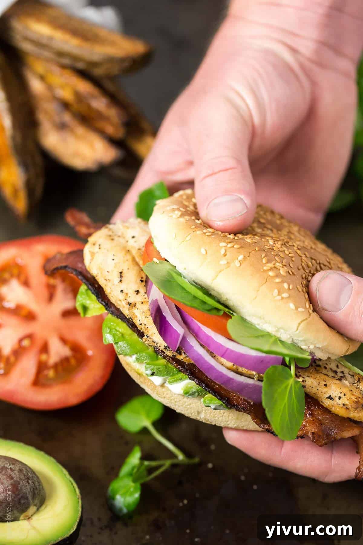 Delicious California Chicken Club Burger with crispy bacon, creamy avocado, and fresh vegetables