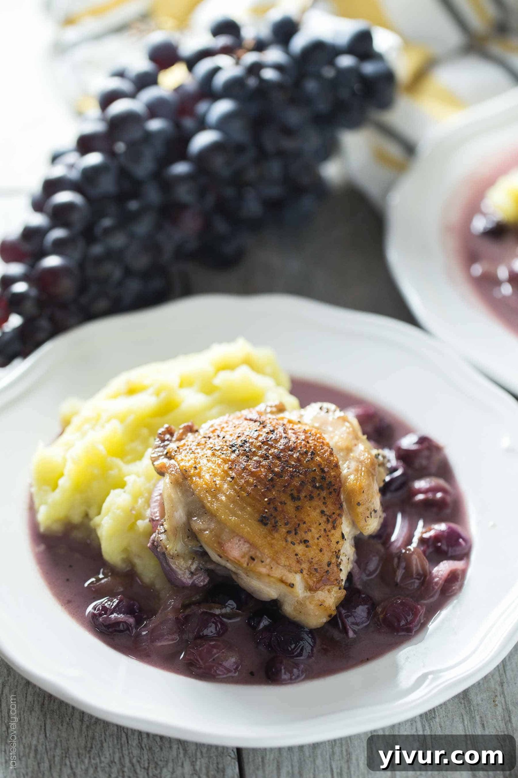 Close-up of braised chicken thighs with grapes in a rich mustard sauce, perfect for family dinners