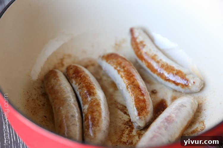 Italian sausage browning in a heavy bottom pot
