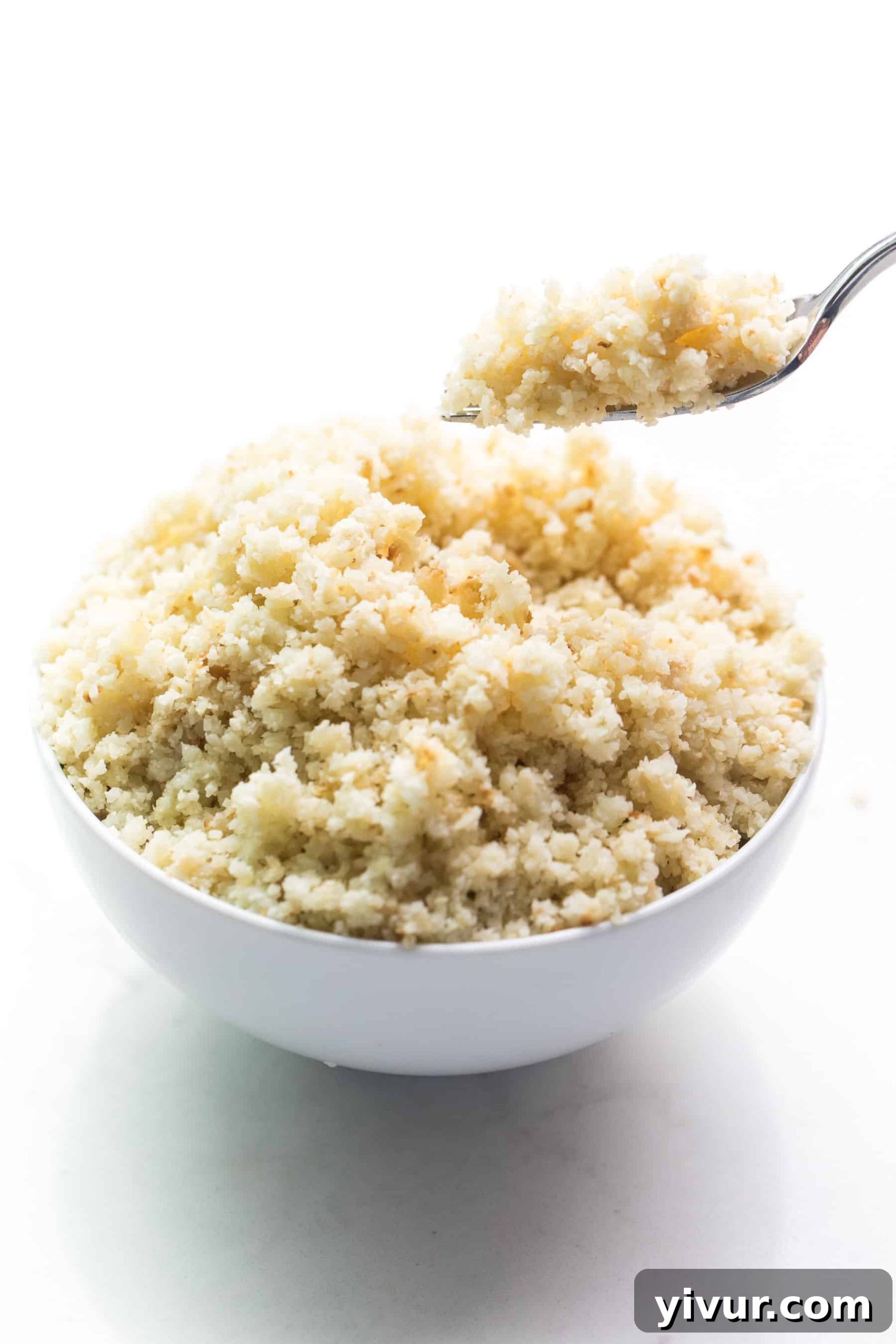 Freshly prepared homemade cauliflower rice in a pristine white bowl, showcasing its light and fluffy texture, ready to be served as a healthy side.