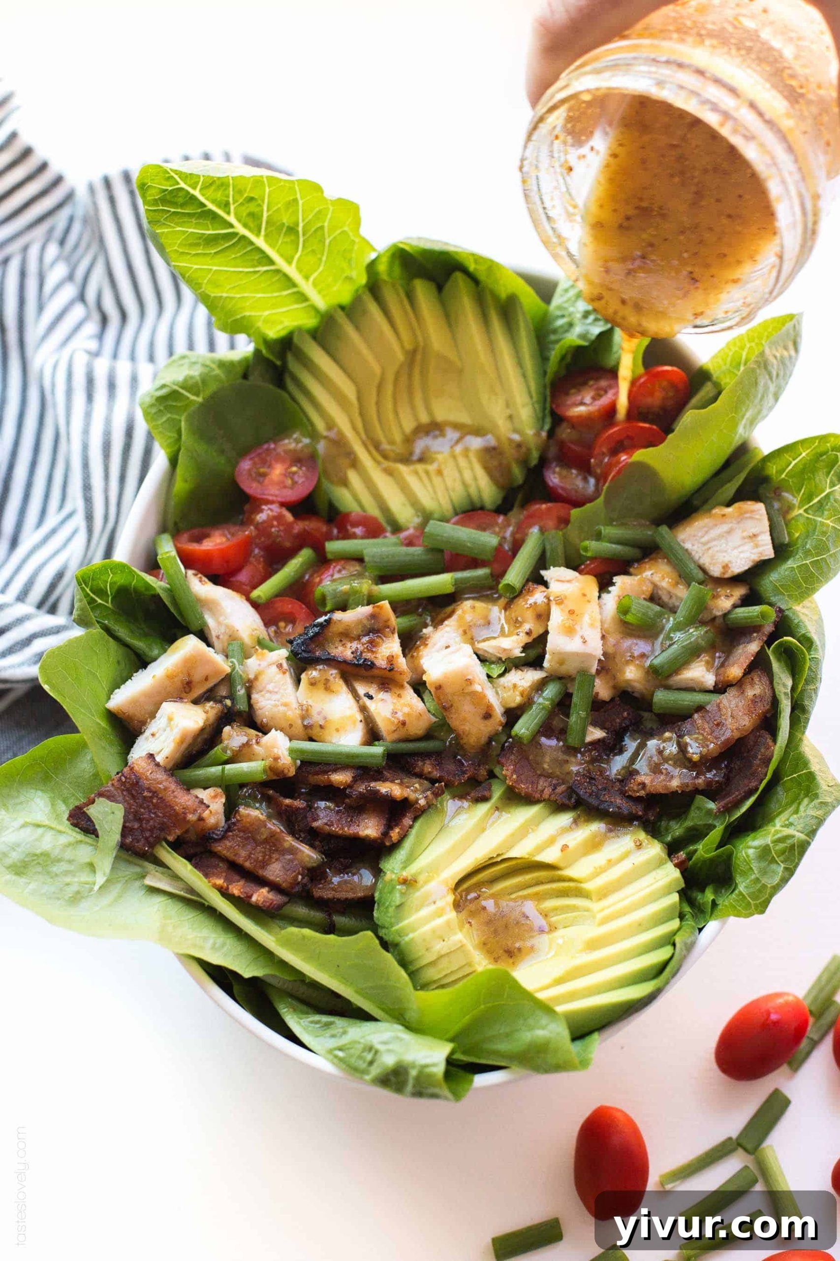 Paleo Honey Mustard Chicken Power Bowl with Crispy Bacon and Avocado 3 Close-up of a refreshing Paleo Honey Mustard Chicken, Bacon & Avocado Salad, highlighting the crisp romaine, colorful cherry tomatoes, and creamy avocado slices.