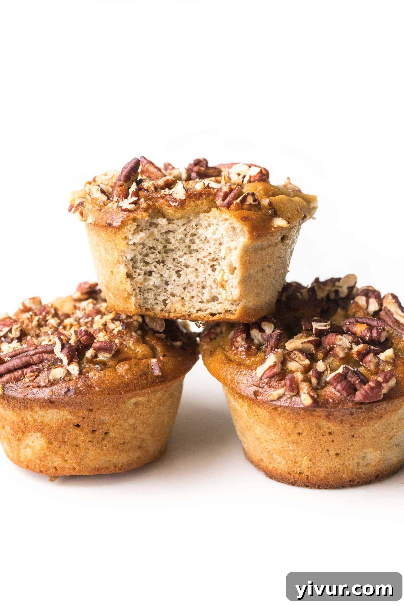 Stacked paleo banana muffins on a white background, highlighting their soft texture and golden tops.