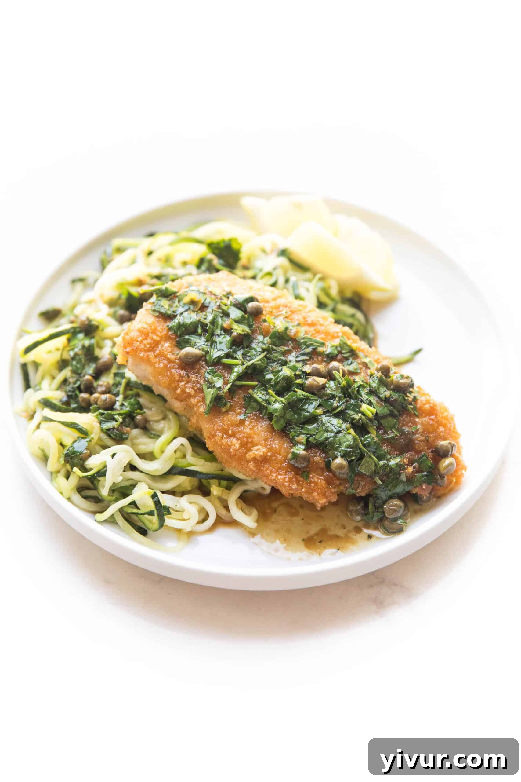 Plated keto chicken piccata close-up with fresh lemon and capers