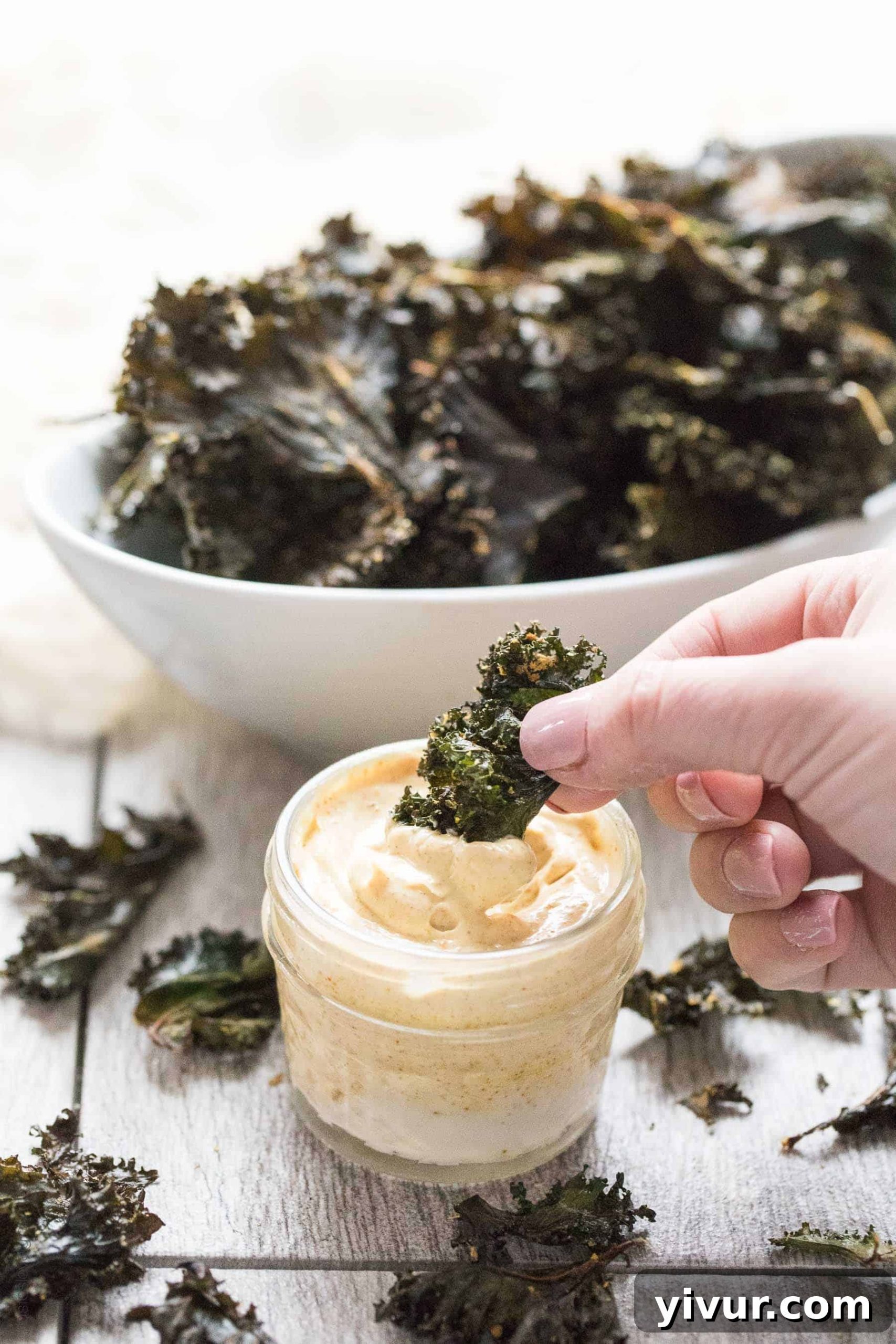 Perfectly Roasted Kale Chips with Creamy Curry Aioli - a crispy, crunchy salty snack that is Paleo & Whole30. Ready in 20 minutes. Served with a curry aioli dipping sauce.