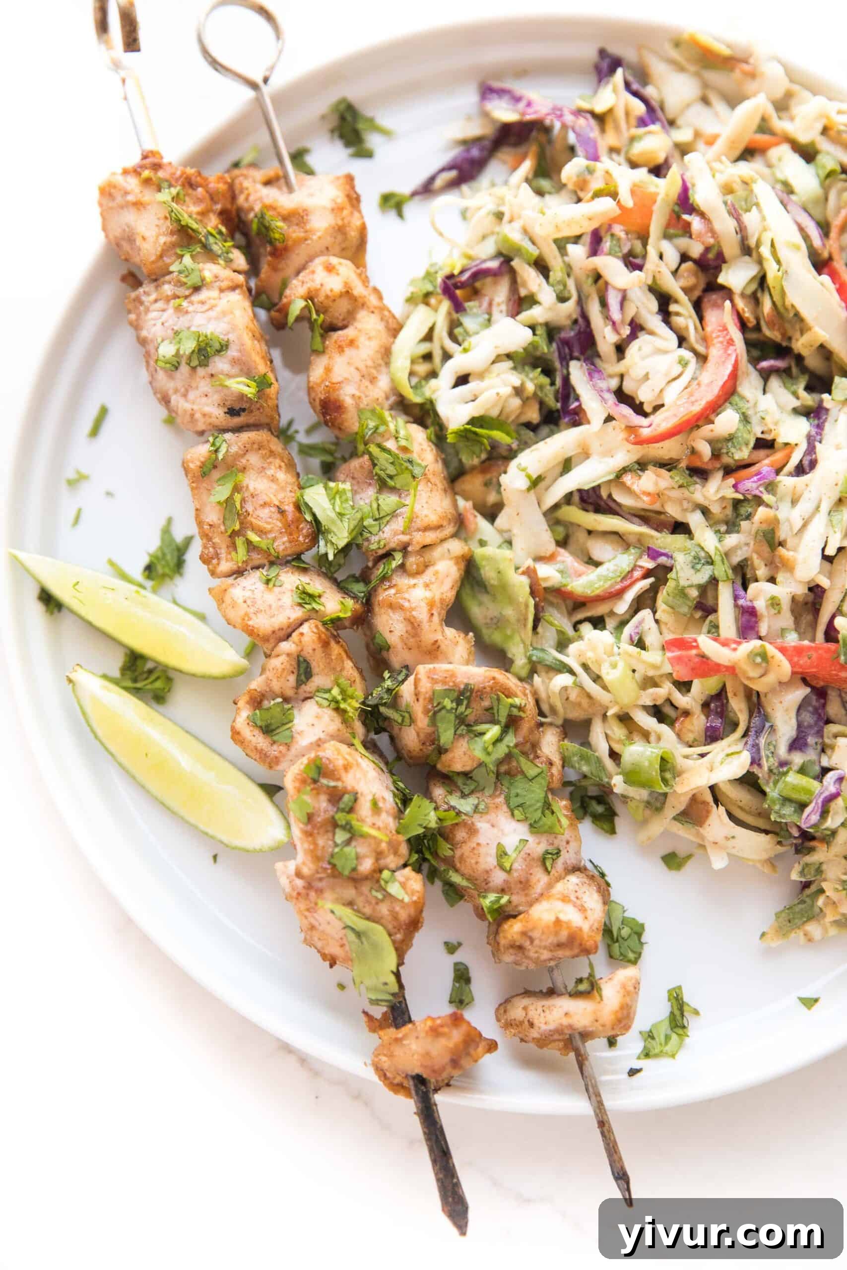 Flavorful Whole30 Keto Thai Chicken Satay Skewers with Crisp Coleslaw 2 Grilled Whole30 Keto Thai Chicken Satay Skewers with fresh herbs and a side of coleslaw