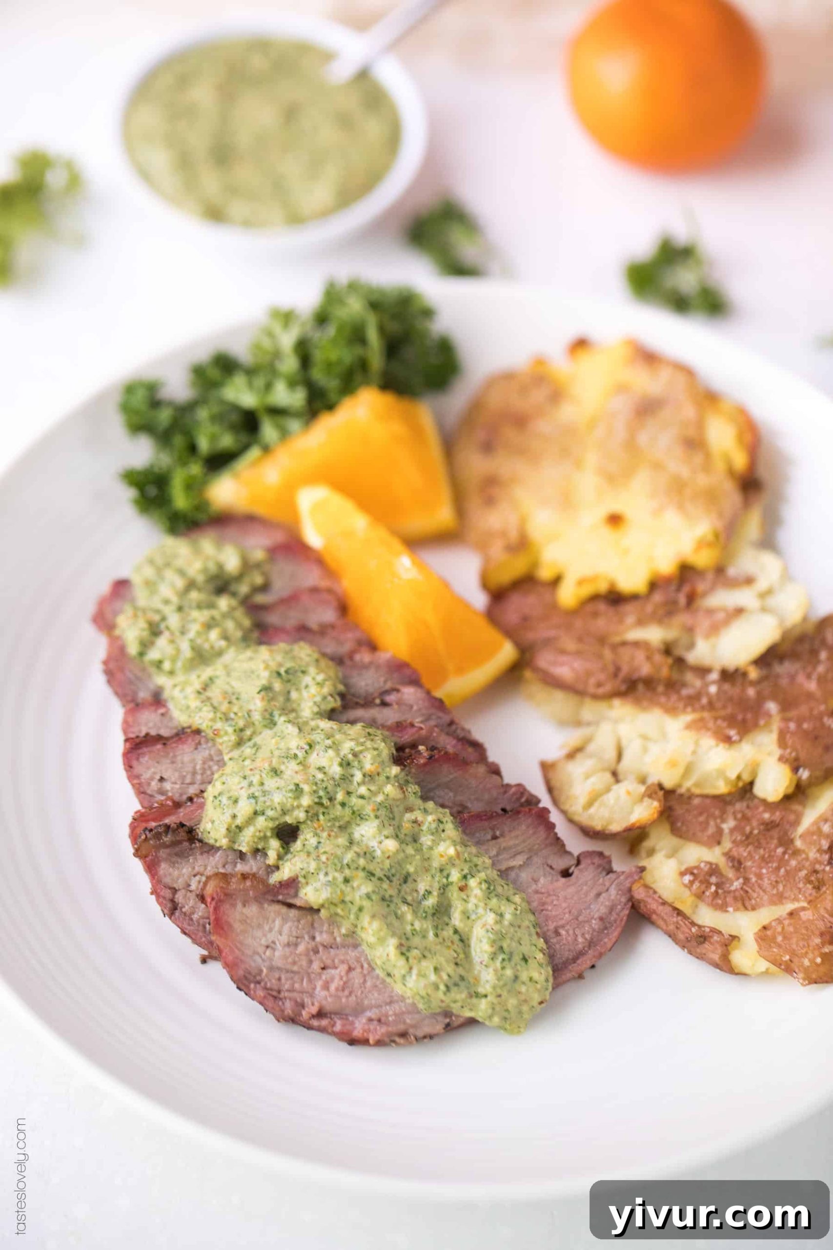 Whole30 Keto Tri Tip with Zesty Orange Parsley Sauce 4 Sliced Whole30 Keto Tri Tip steak on a cutting board, ready to be served with orange parsley sauce. Highlights the tenderness and perfect grill marks.