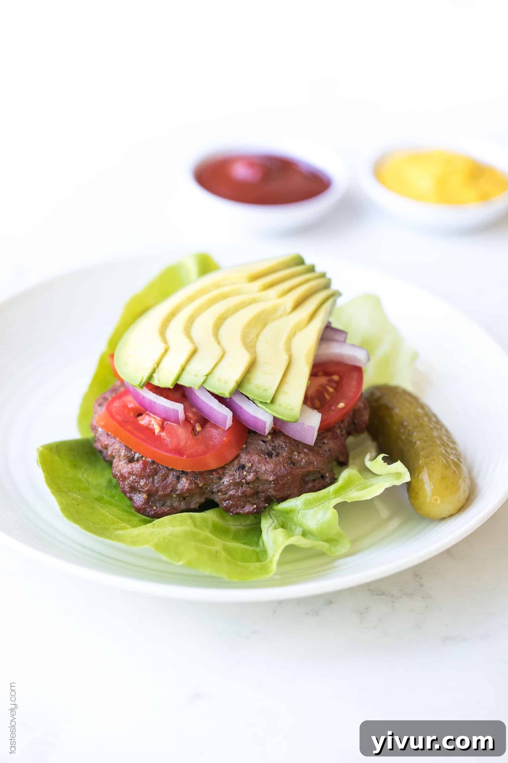 A stack of savory keto burger patties, cooked to perfection and ready to be assembled with fresh, low-carb ingredients.