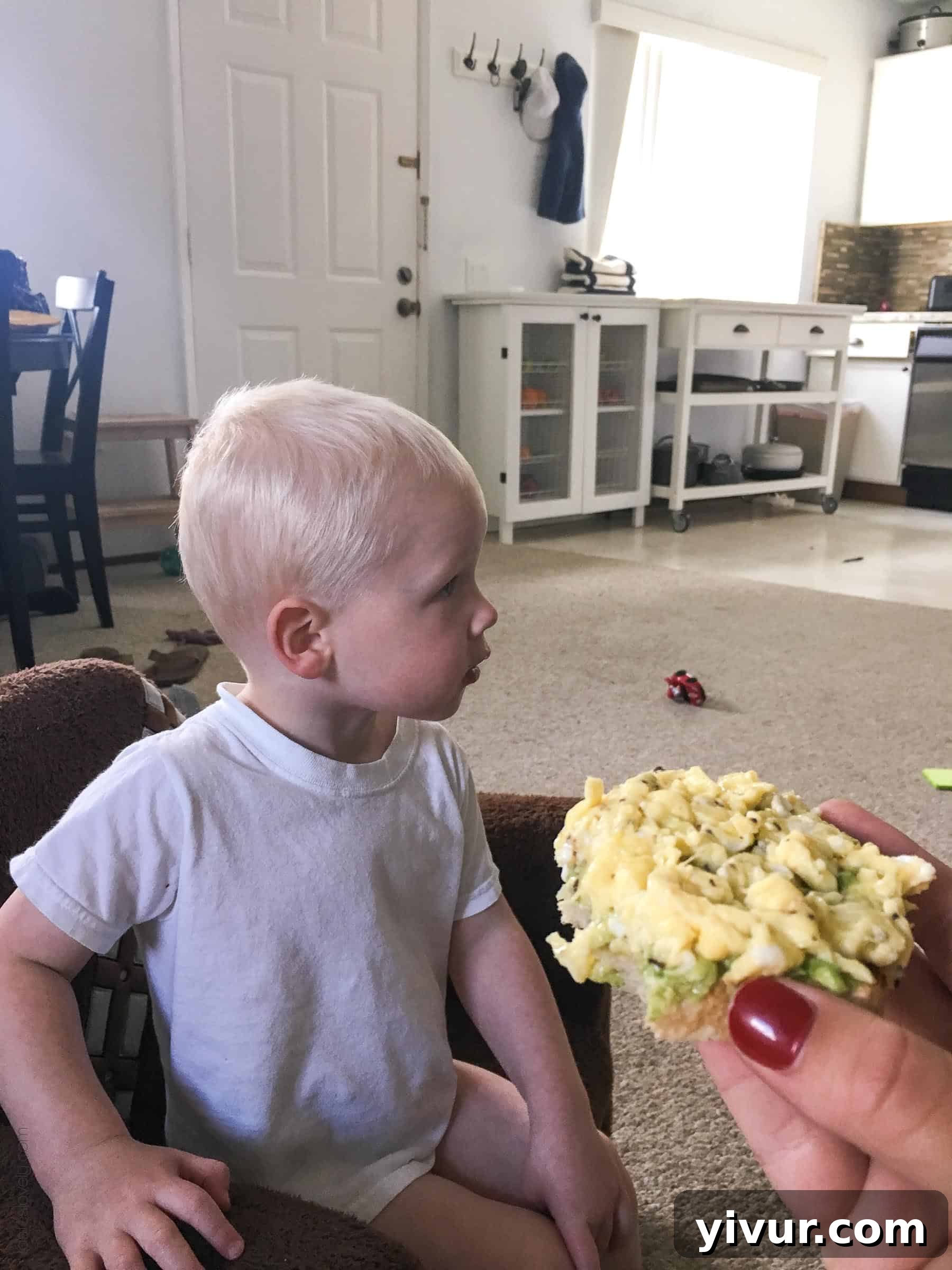 Spring 2018 A Daily Perspective 3 Toddler Josh watching tractors from the window while cuddling with his pregnant mom, a typical morning scene.