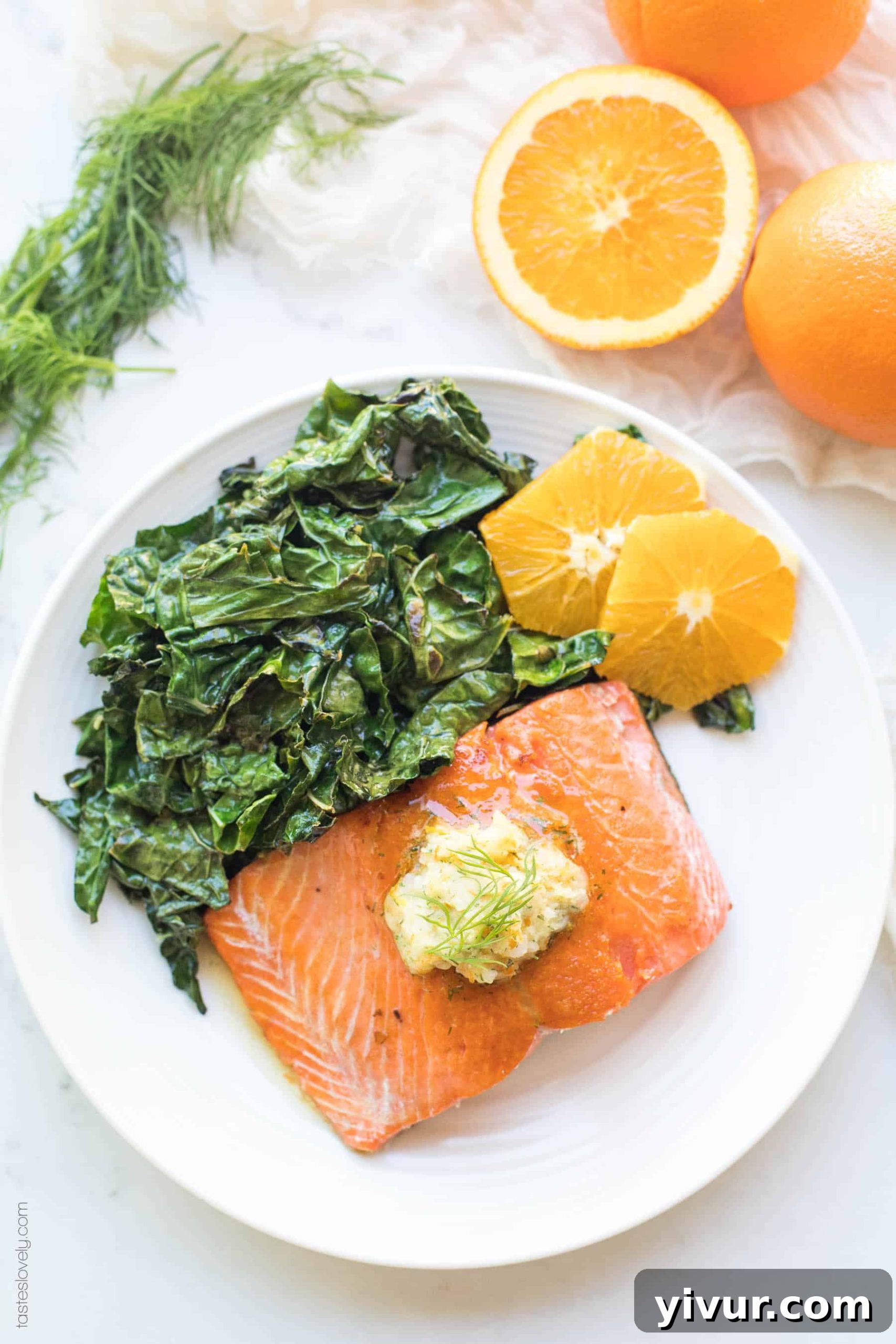 Vibrant Orange Dill Butter Salmon Whole30 Paleo Keto Friendly 3 Close-up of a cooked salmon filet with crispy skin, fresh kale, and orange slices arranged aesthetically.