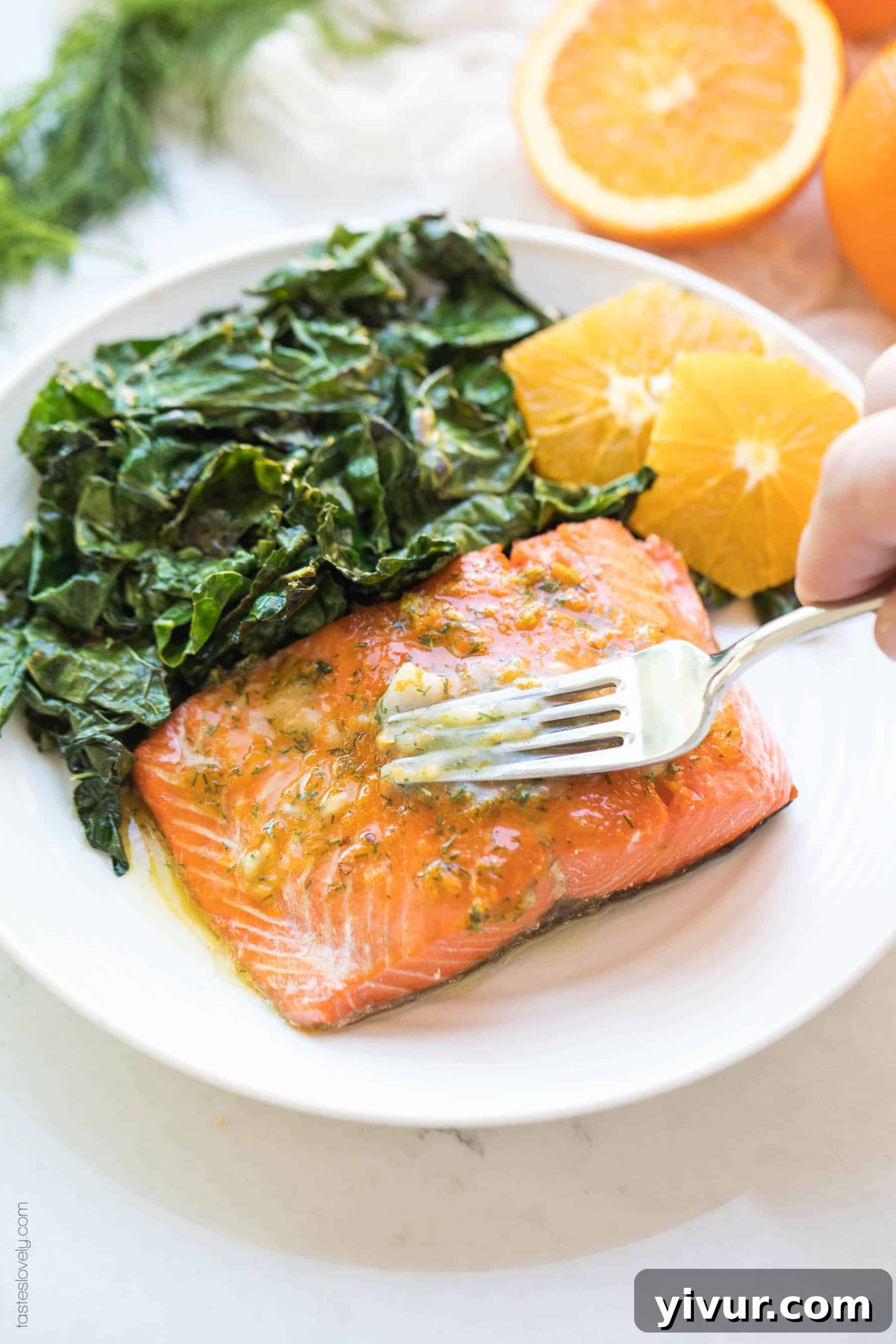 Vibrant Orange Dill Butter Salmon Whole30 Paleo Keto Friendly 5 Plated salmon filet topped with orange dill butter, alongside fresh orange slices and sautéed kale.