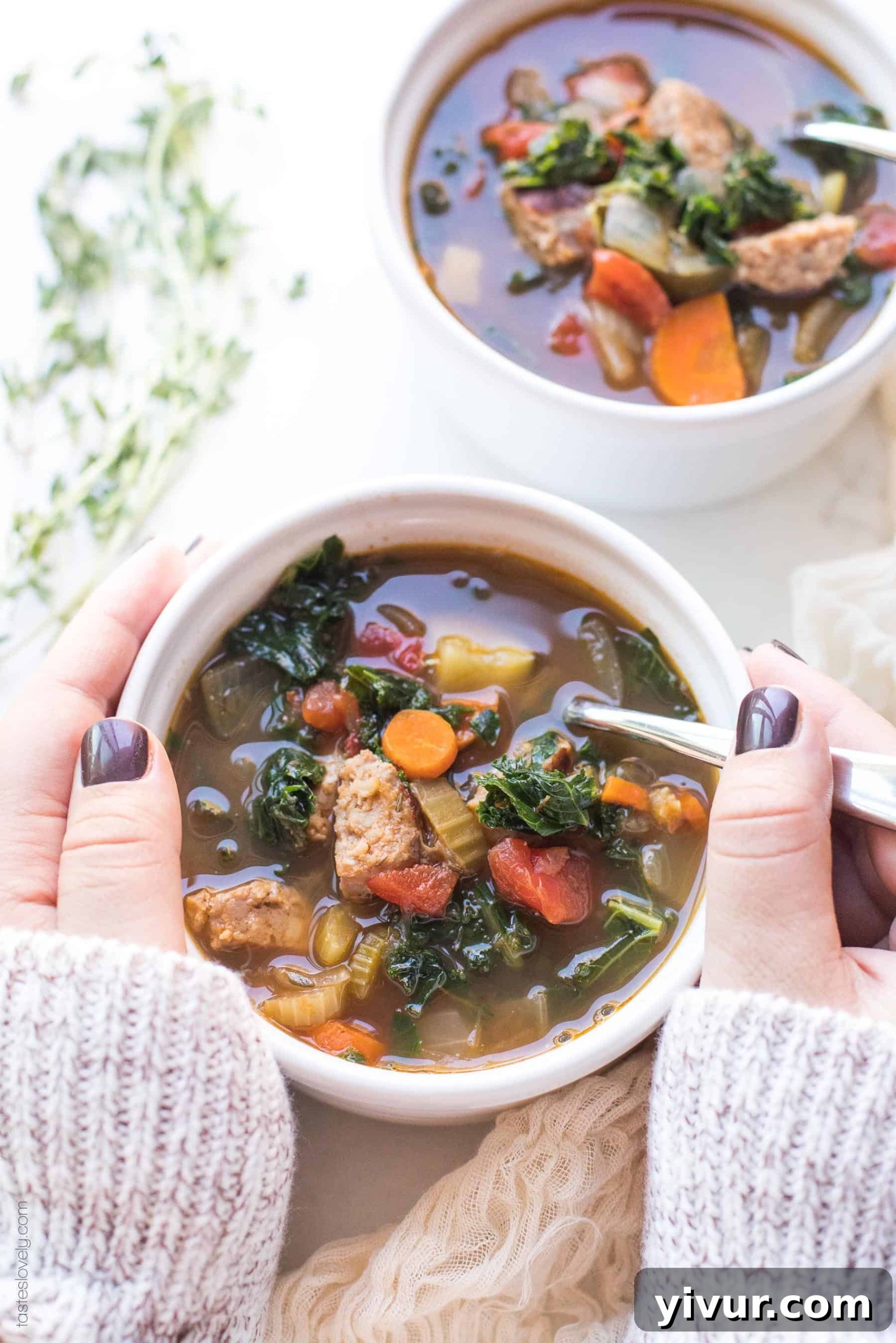 Two hands holding a comforting bowl of Whole30 Keto Italian Sausage and Kale Vegetable Soup, perfect for a healthy and satisfying meal.