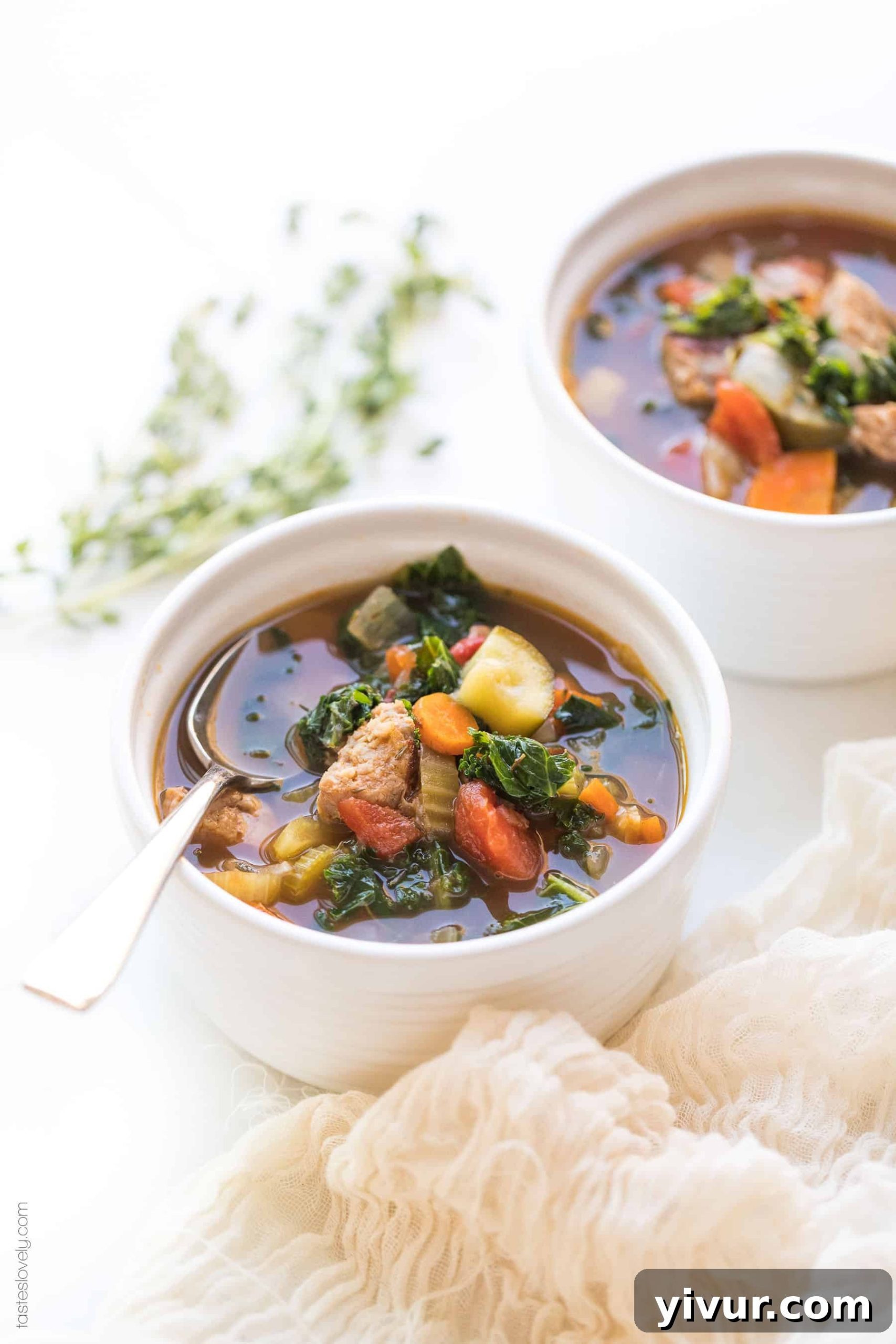 Two bowls of Whole30 Keto Italian Sausage and Kale Vegetable Soup side-by-side, showcasing the vibrant colors and hearty ingredients.