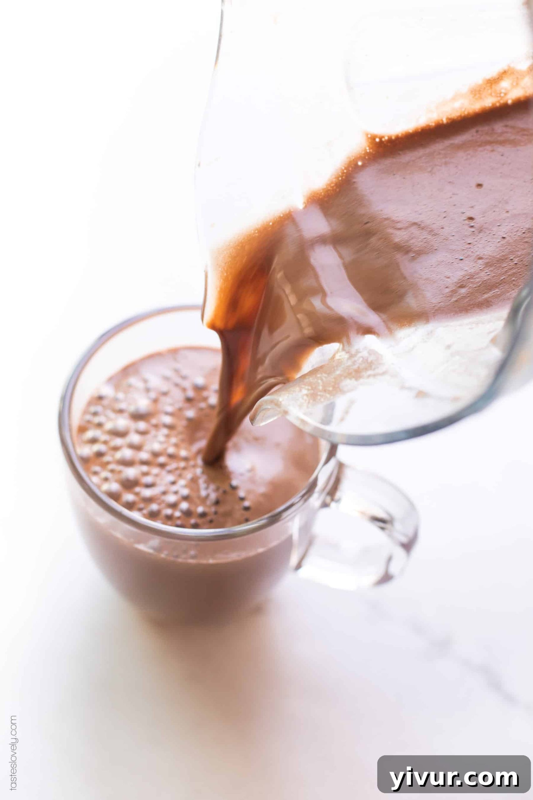A freshly blended mocha being poured into a coffee cup, showing its rich, frothy texture