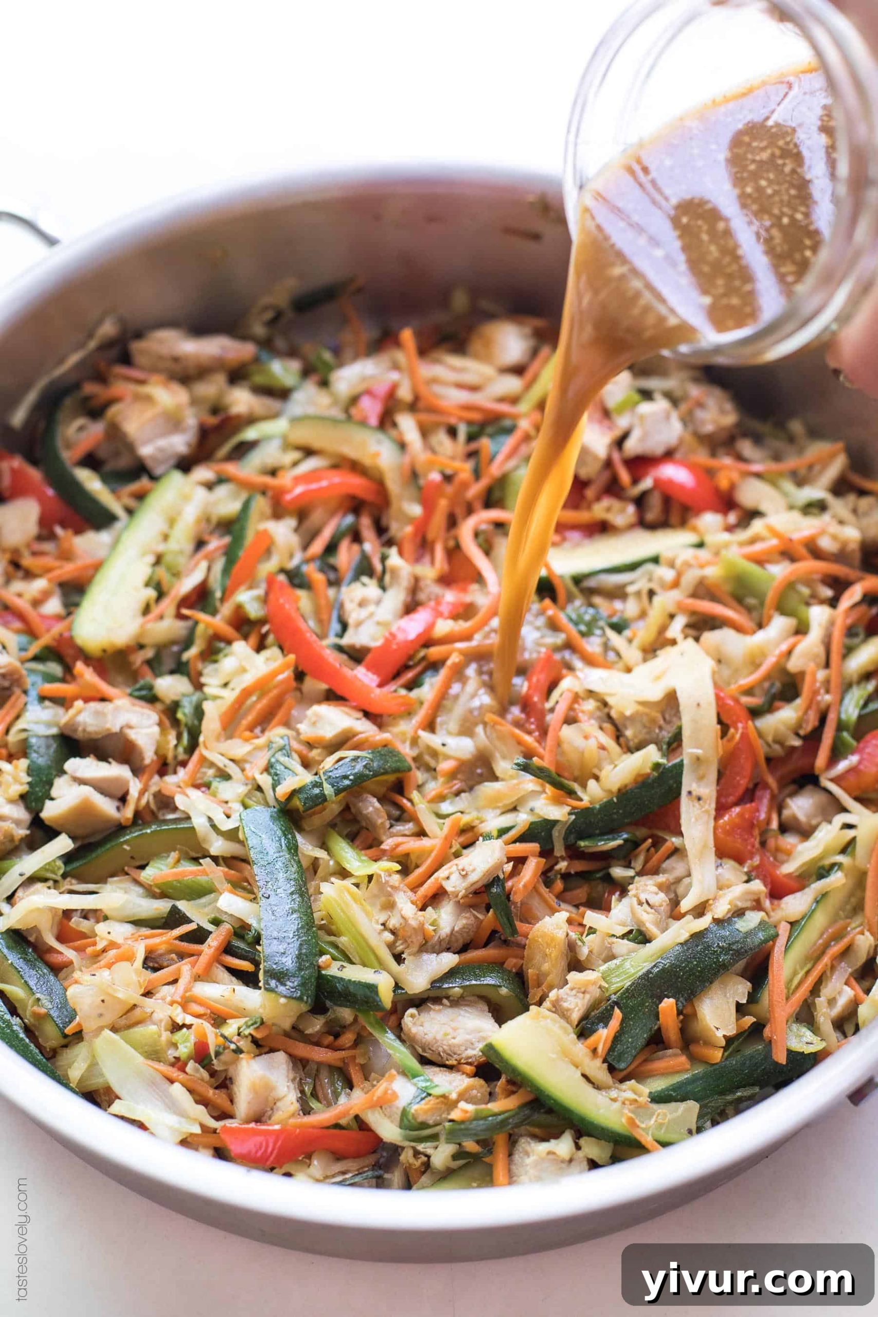 Delicious 5 Minute Whole30 and Paleo Stir Fry Sauce Soy Free 2 Stir fry sauce poured into a pan of chicken stir fry, showcasing its glossy texture