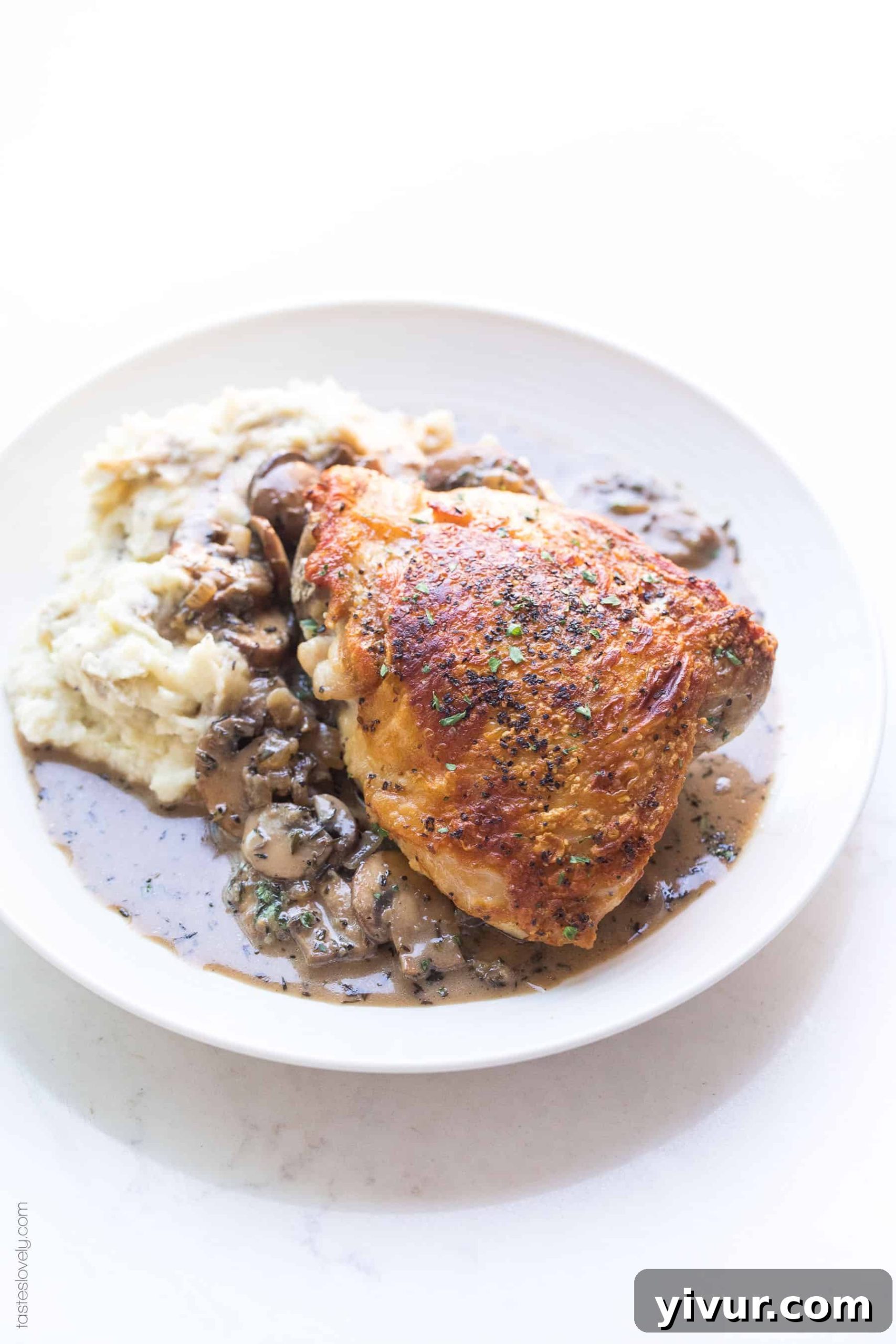 Luxurious Creamy Mushroom Chicken Thighs for Whole30 and Keto 6 Crispy chicken thighs served on a plate with mashed cauliflower and a generous drizzle of creamy mushroom gravy