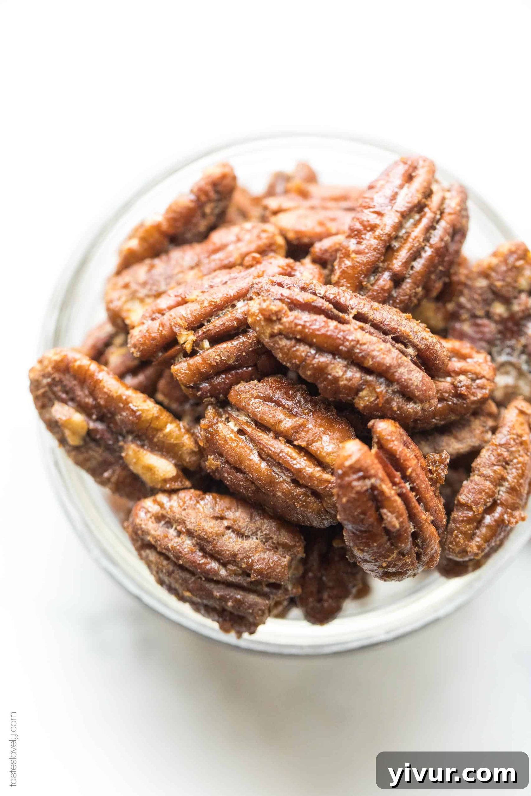 A small rustic bowl overflowing with golden-brown paleo candied pecans, ready for snacking.