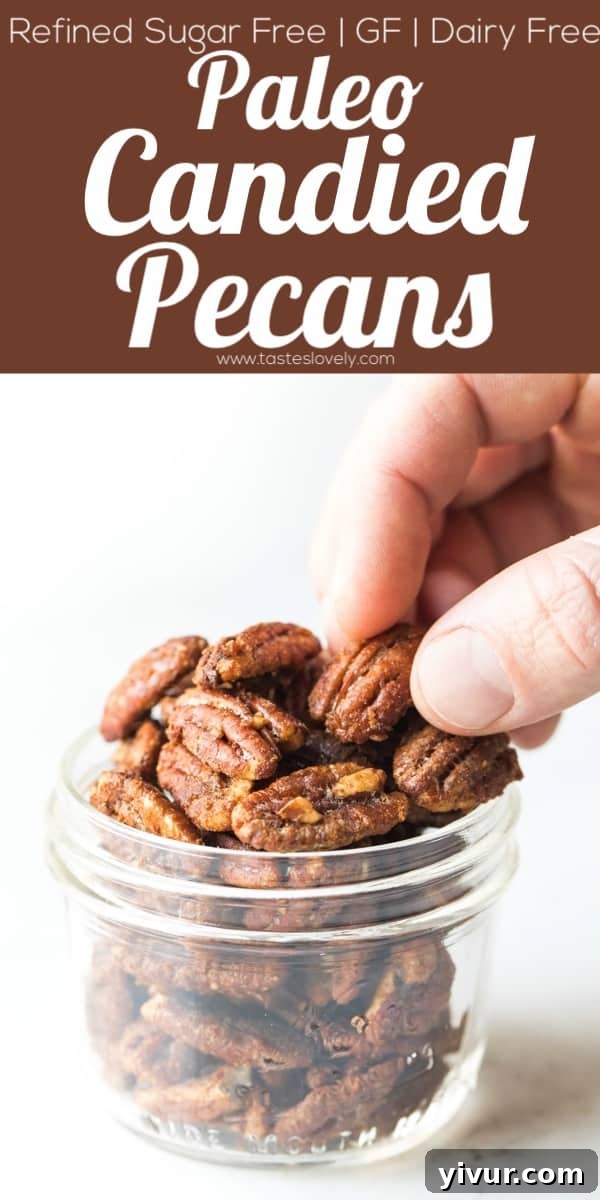 A tall glass jar filled with healthy paleo candied pecans, tied with a string, suggesting it's perfect for gifting.