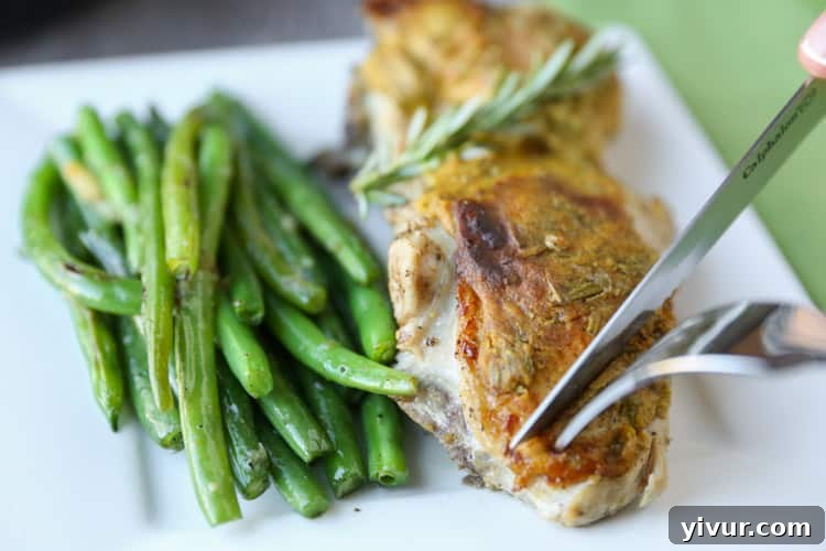 A close-up of Rosemary Mustard Skillet Chicken on a plate, showcasing its golden crust