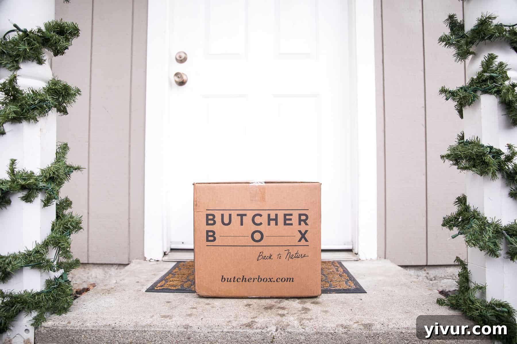 A perfectly cooked steak on a white plate with herbs, showcasing the quality of ButcherBox beef