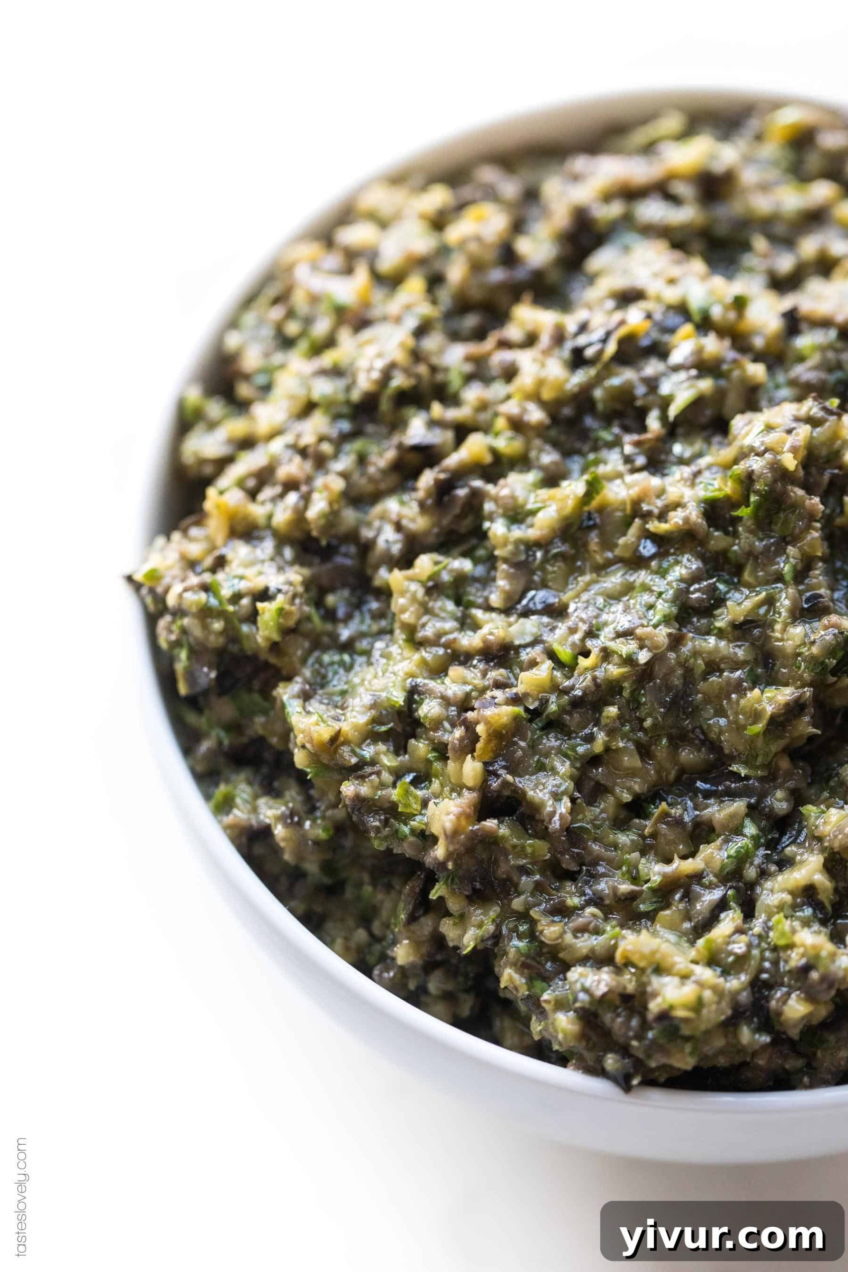 A close-up shot of freshly prepared olive tapenade presented in a small white serving bowl, ready to be enjoyed.