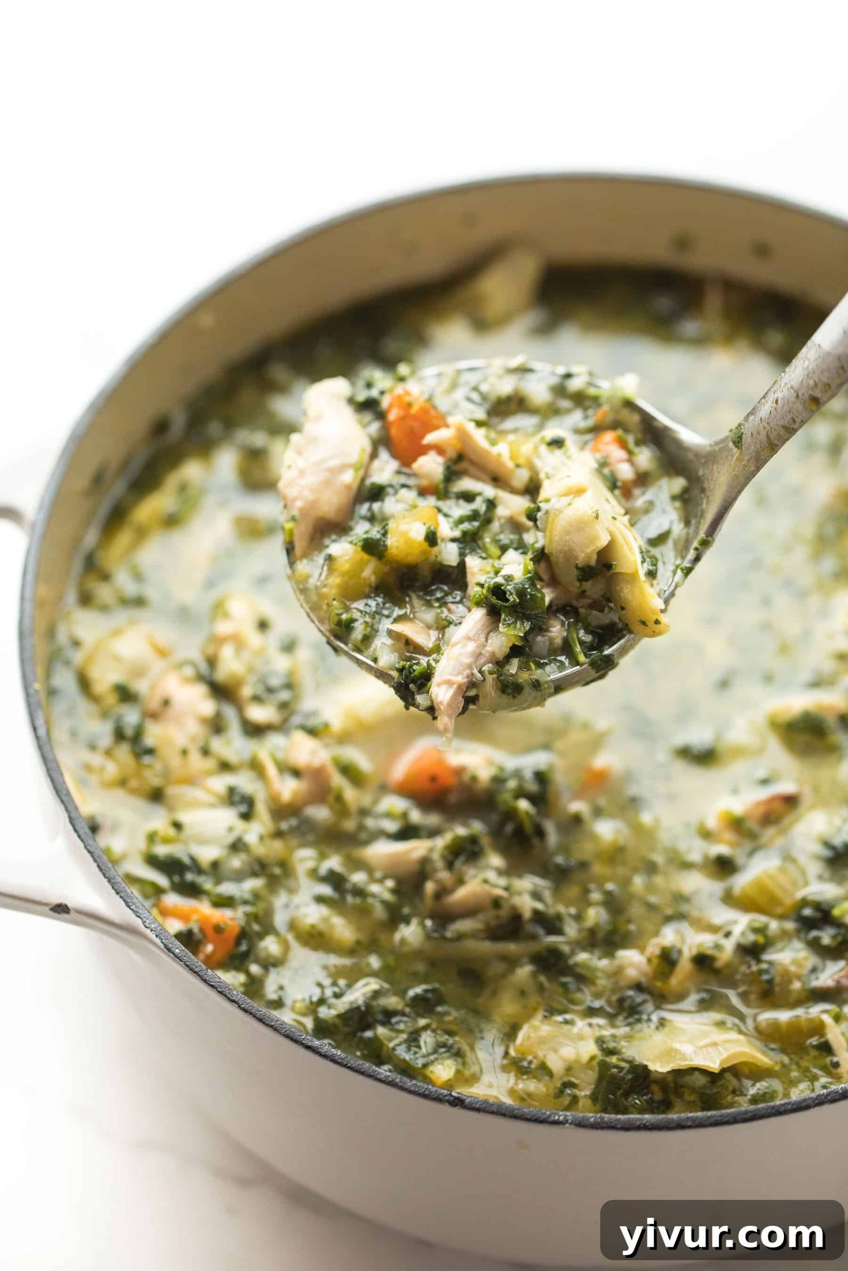 Zesty Lemon Artichoke Chicken Soup Whole30 Keto 3 Lemon Artichoke Chicken Soup being served directly from a rustic Dutch oven, showcasing the rich texture and ample ingredients within the pot.