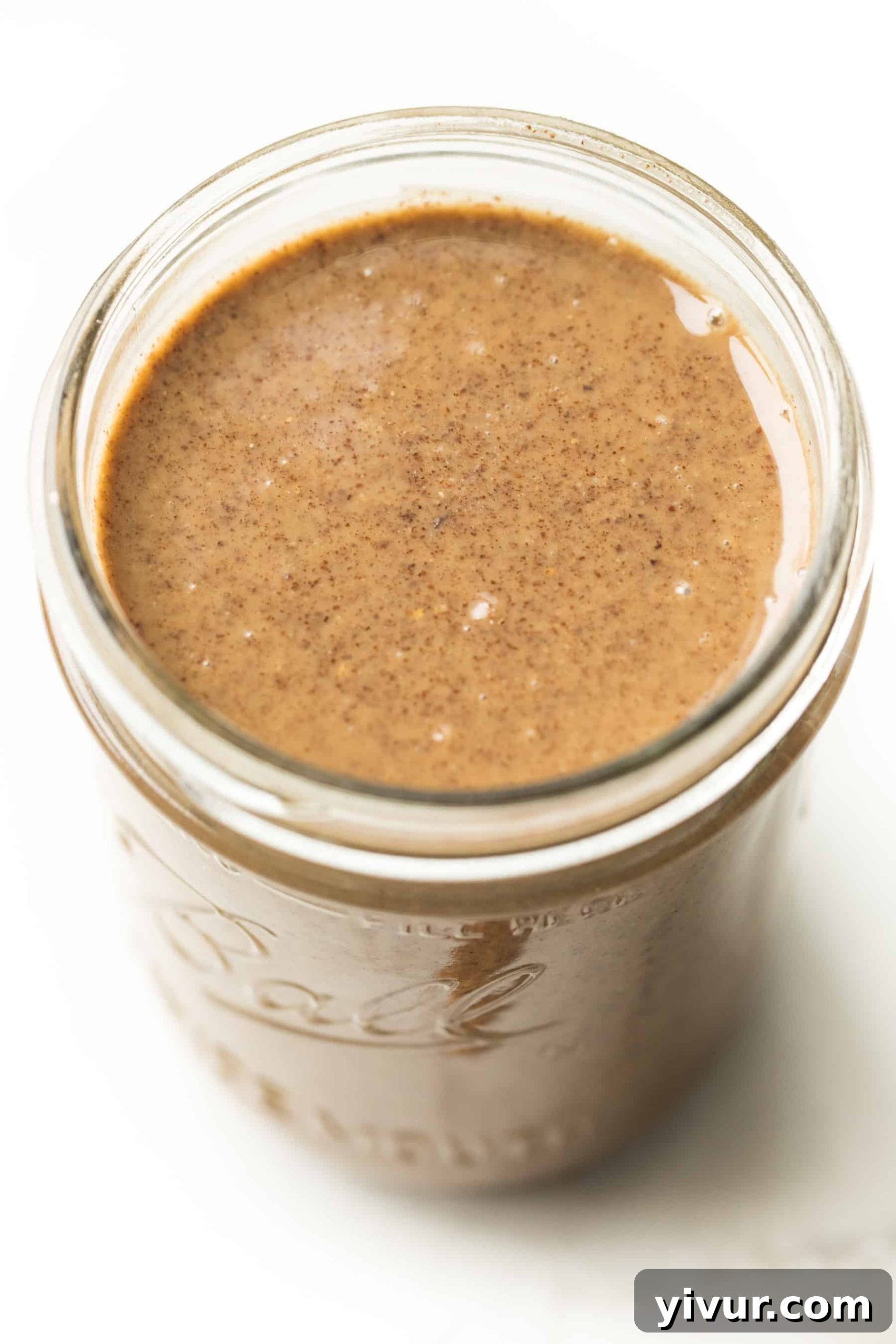 Creamy Paleo Whole30 Homemade Pecan Butter 3 A mason jar filled with freshly made homemade pecan butter, highlighting its smooth, golden-brown appearance and suitability for healthy eating.