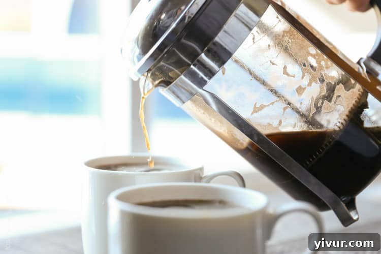 Unlock Barista-Quality French Press Coffee At Home 7 Freshly brewed French press coffee being poured into a ceramic mug.