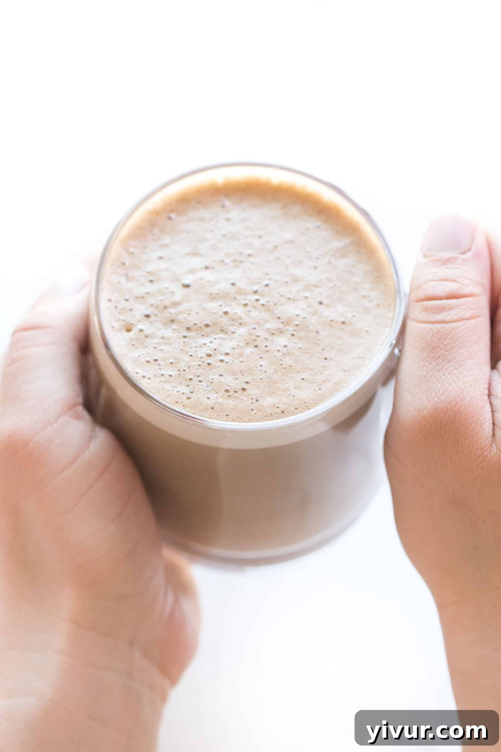 Making creamy cashew bulletproof coffee in a blender with healthy fats.