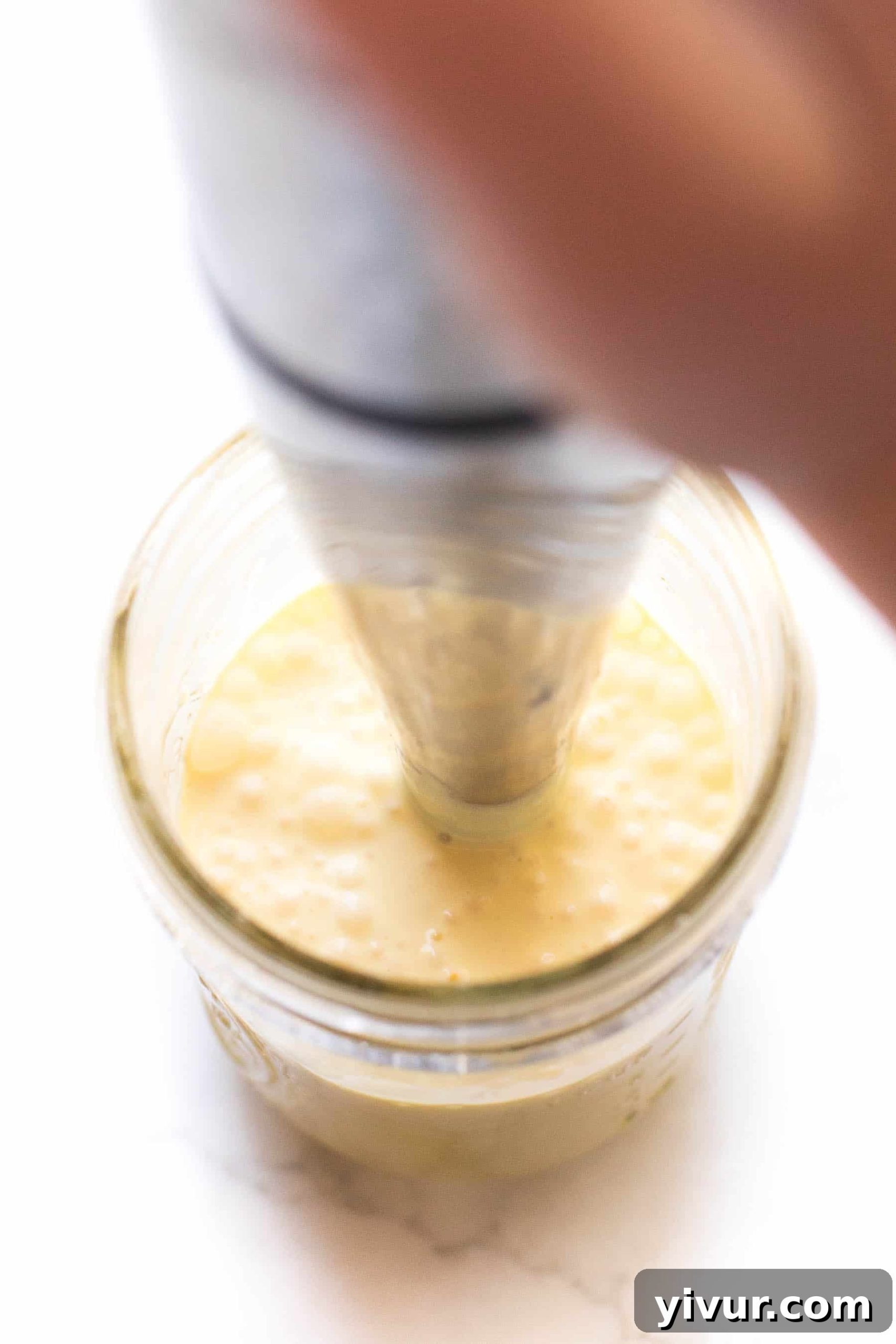 No-Fail Whole30 Hollandaise Sauce Paleo Keto Approved 5 Immersion blender actively mixing hollandaise sauce in a mason jar