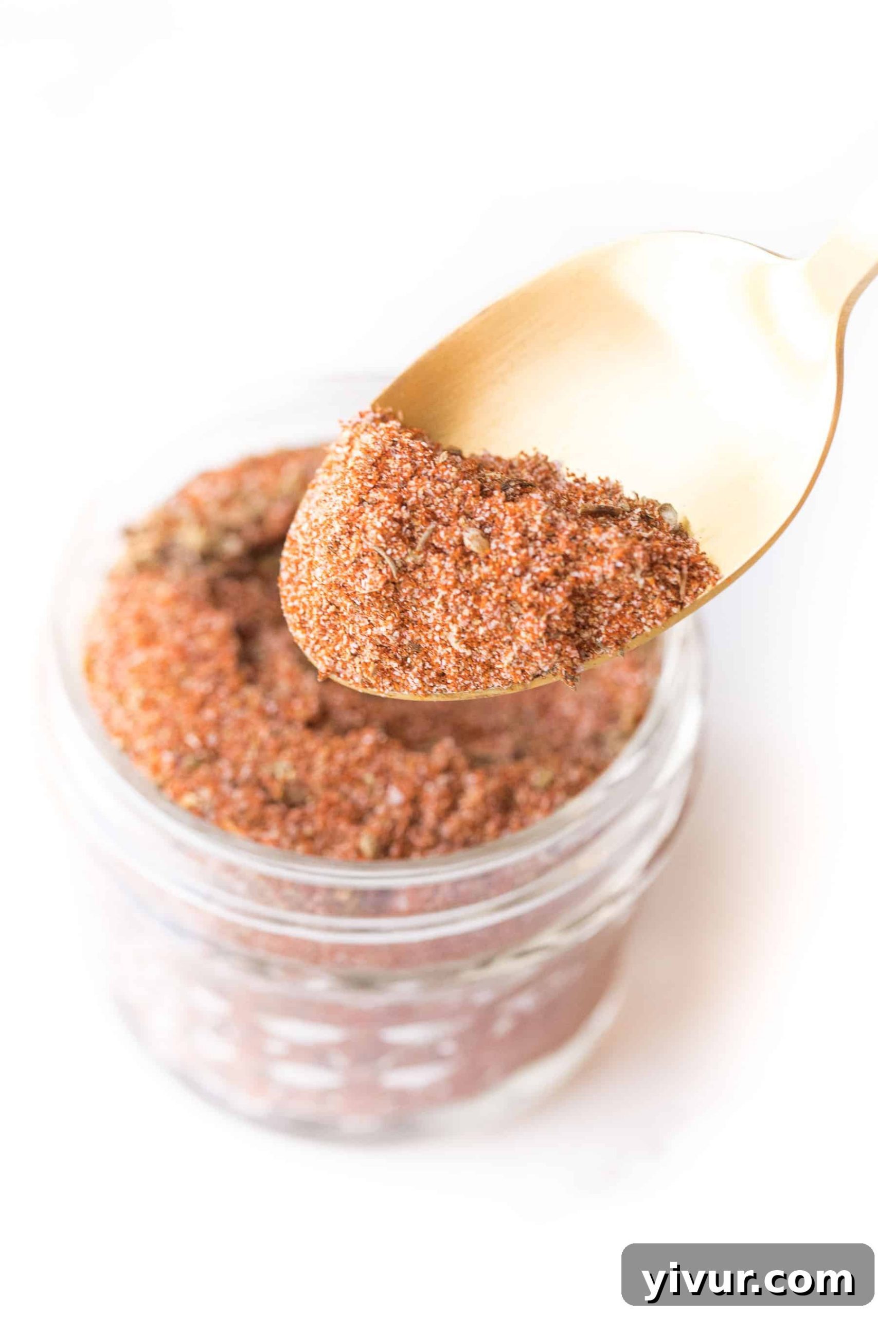 spoon of cajun seasoning on a white background