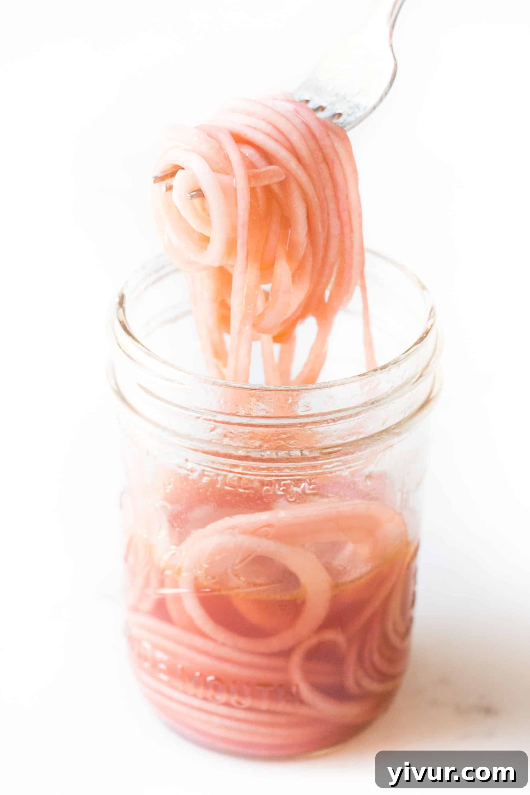 pickled onions in a mason jar on a white background