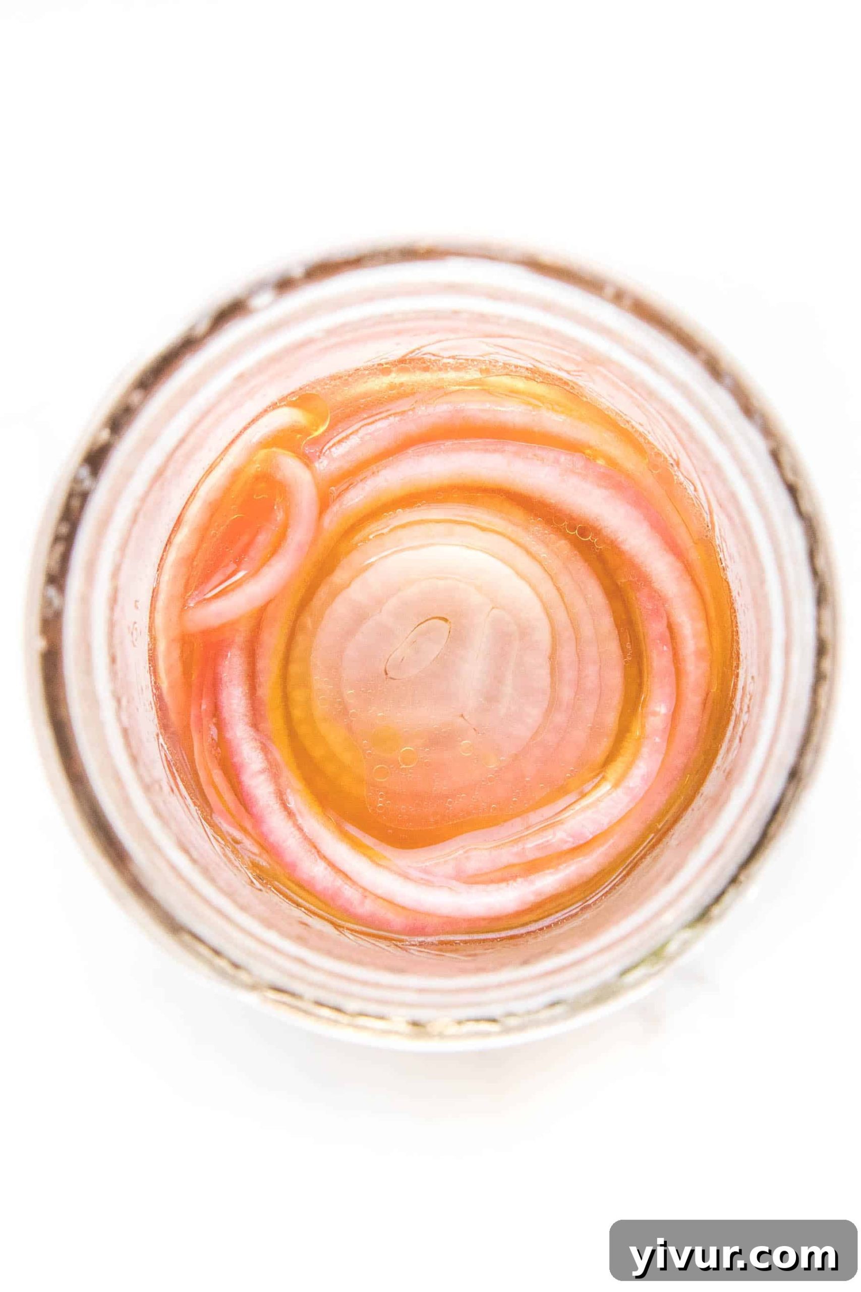pickled onions in a mason jar on a white background